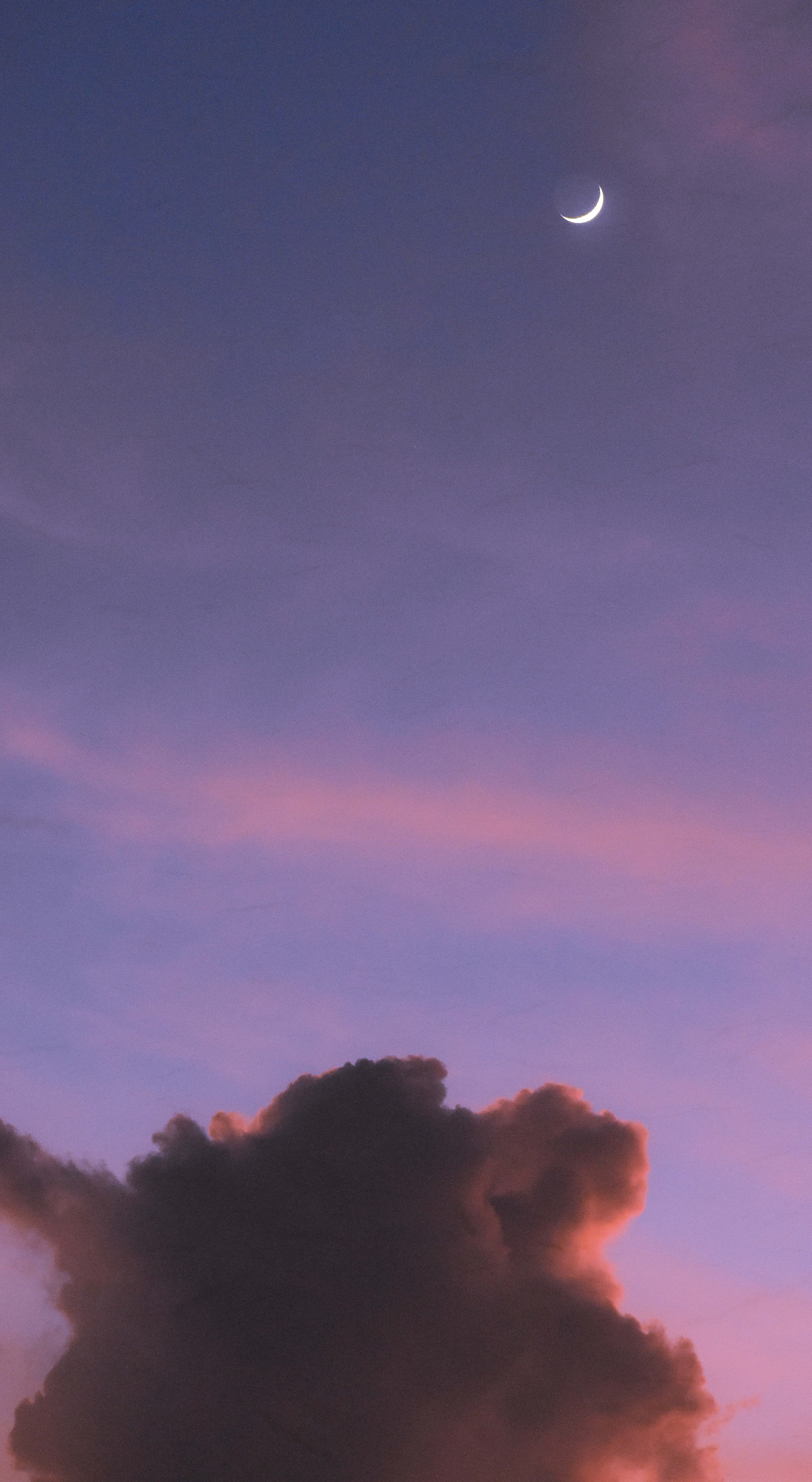 Aesthetic Night Sky 桌布 壁紙 — 一彎精緻的新月在沐浴於暮色粉紅與紫色調的戲劇性雲層上方閃耀。