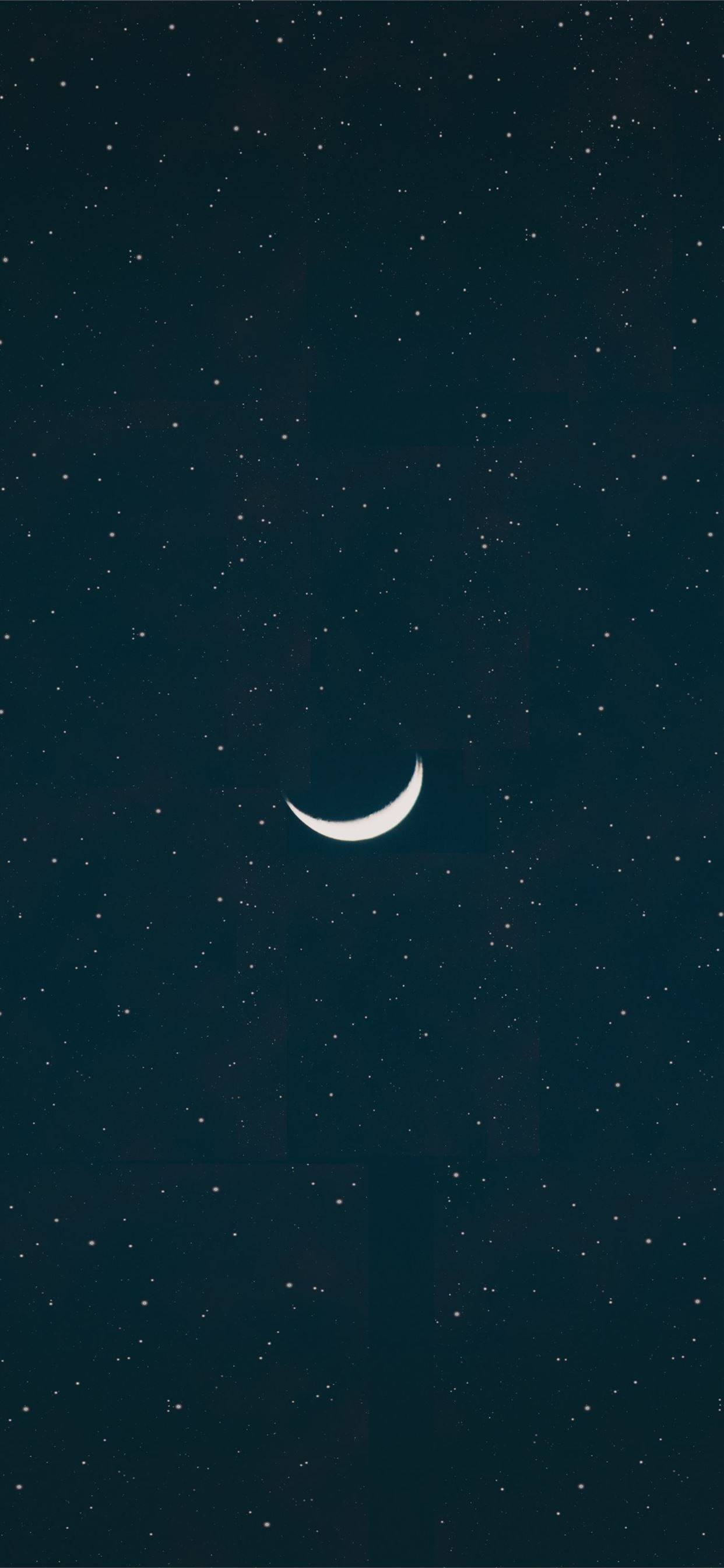 月光 桌布 壁紙 — 一彎精緻的月牙在深藍色的夜空中柔和地發光，點綴著無數遙遠的星星。