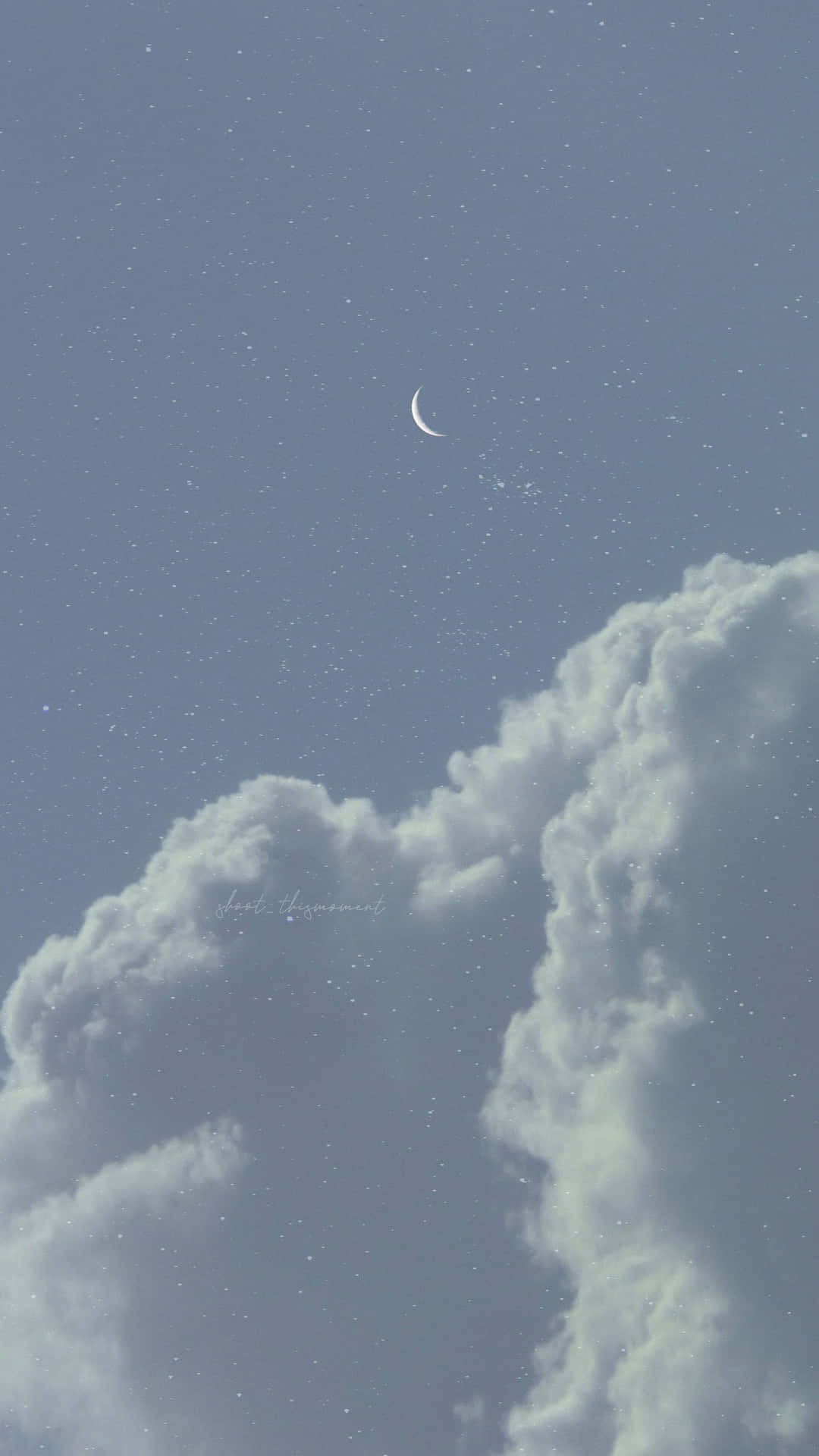 Aesthetic Night Sky 桌布 壁紙 — 一彎精緻的月牙在繁星點點的暮色天空中，在蓬鬆的雲朵上方閃耀。