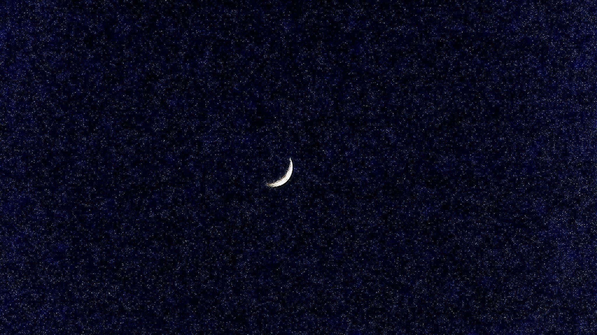 月亮與星星 桌布 壁紙 — 一彎纖細的月牙在深藍色、點綴著無數遙遠星星的夜空中柔和地發光。