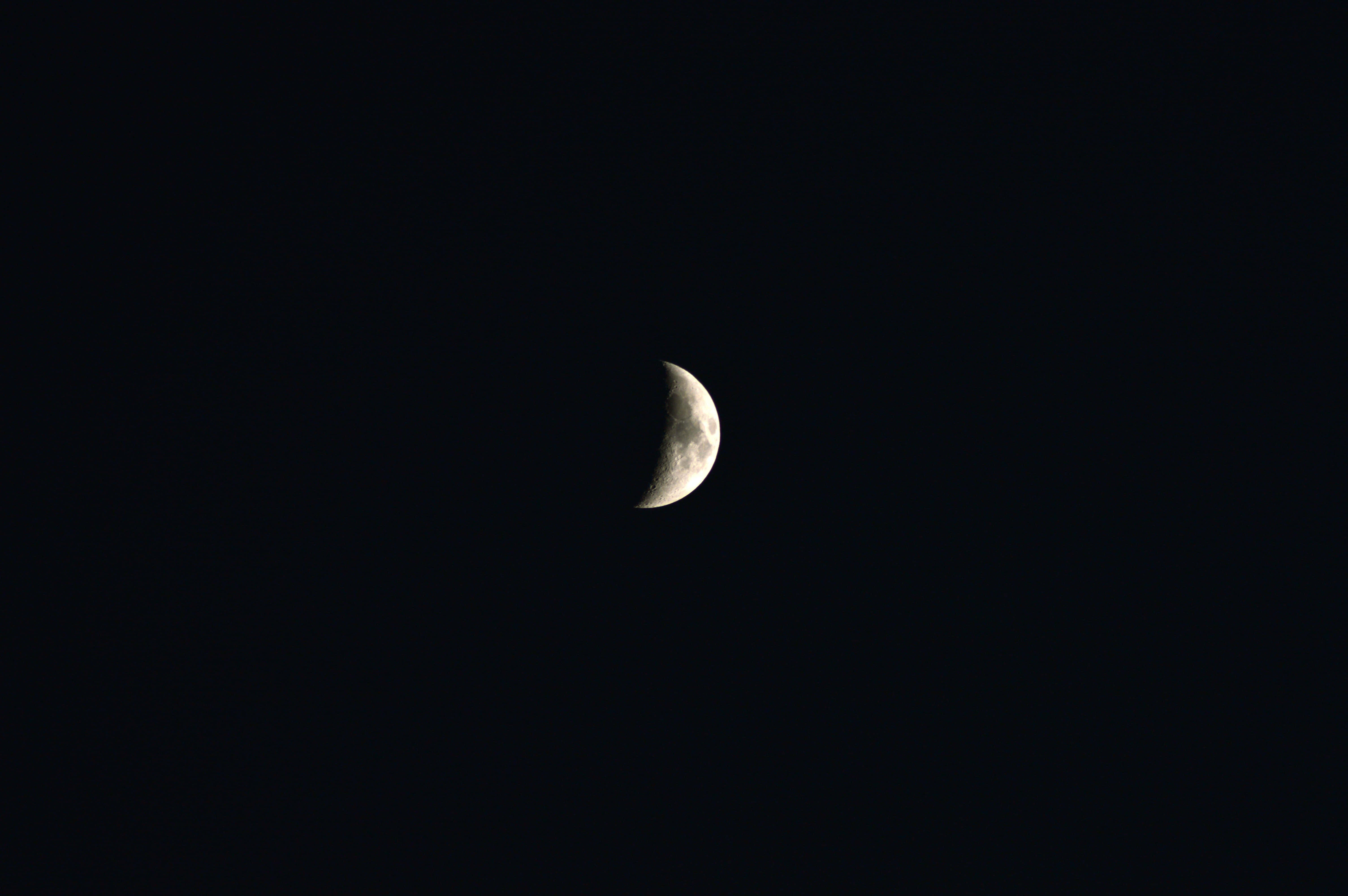 Half Moon 桌布 壁紙 — 一彎纖細的月牙在深邃的黑色夜空中柔和發光。