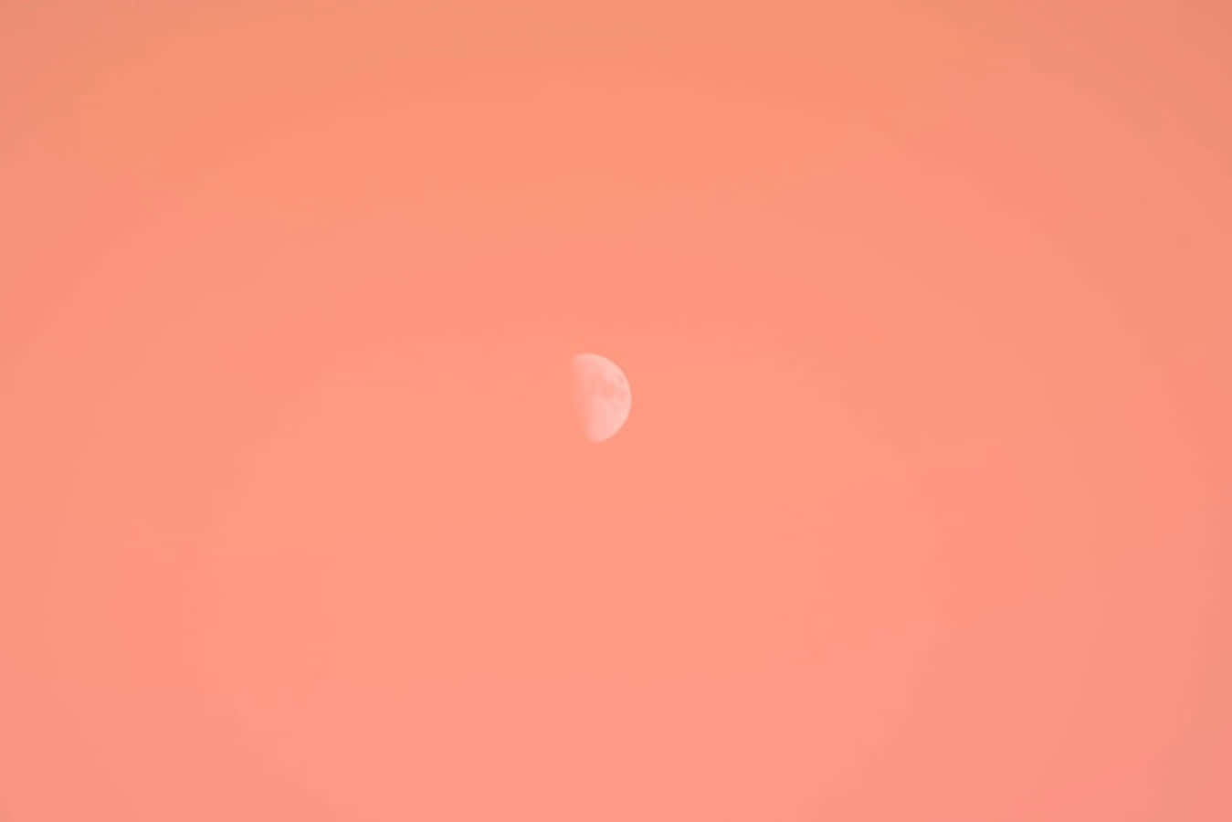 Moon Aesthetic 桌布 壁紙 — 一彎纖細的月牙在溫暖的蜜桃色和珊瑚色調的廣闊漸變天空中柔和地發光。