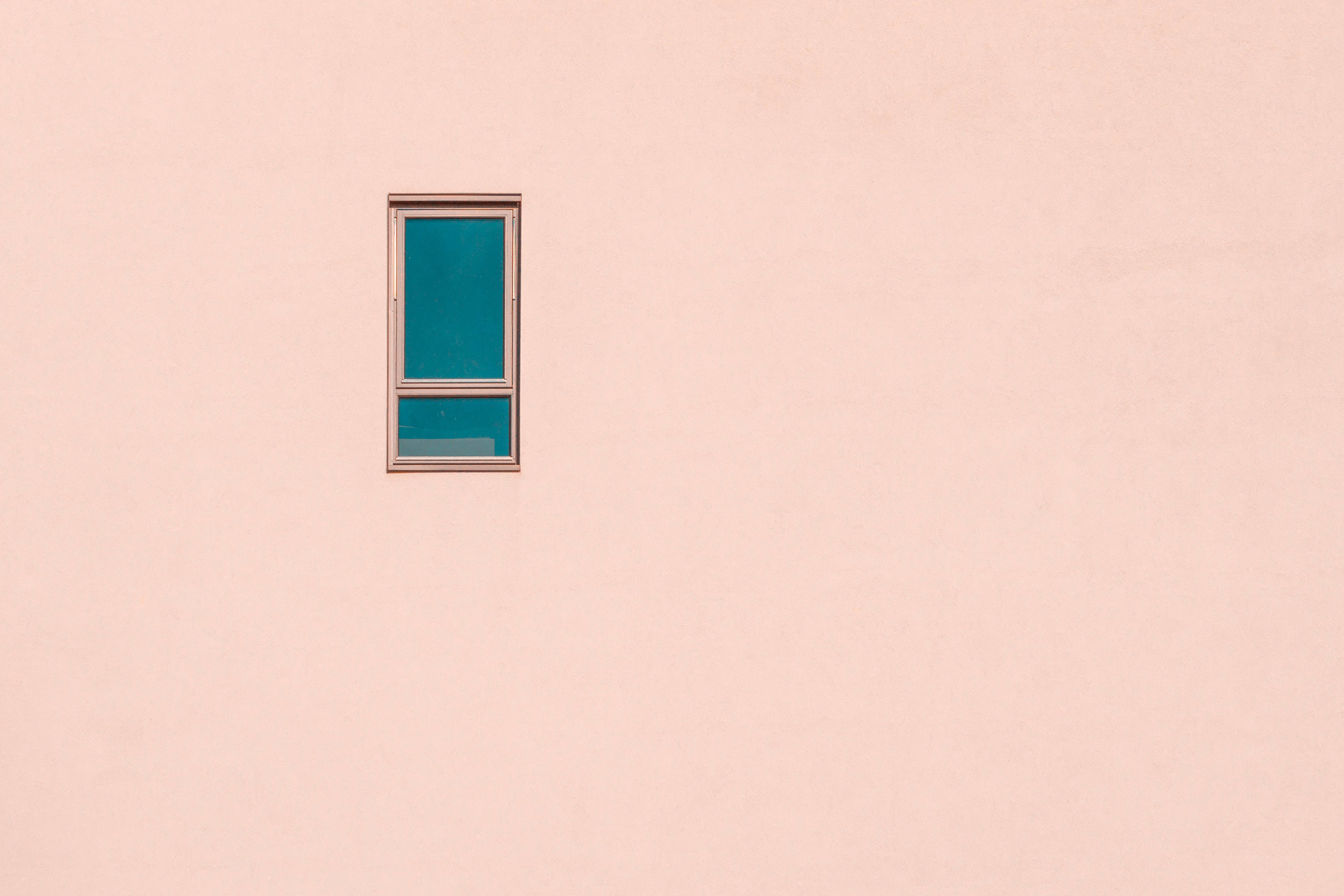 pastel 桌布 壁紙 — 一扇單一的青綠色窗戶設置在極簡風格的淡粉色牆壁上，營造出引人注目的色彩對比。