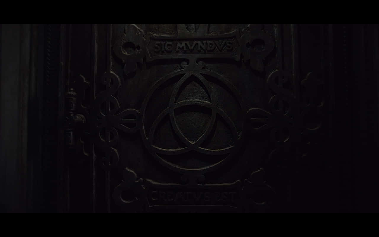 dark black 桌布 壁紙 — 一扇昏暗的裝飾金屬門，在詭異的陰影下帶有三角符號和拉丁文銘文。