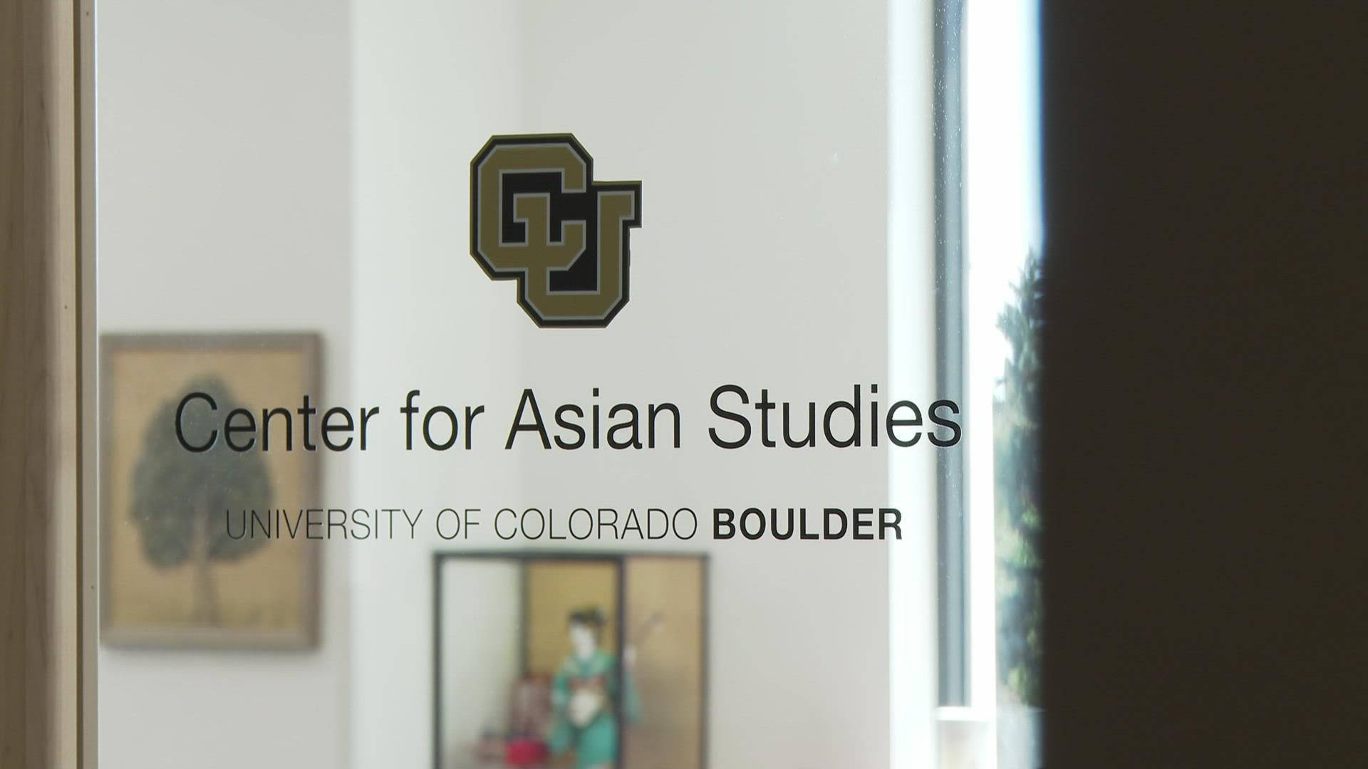 Colorado 桌布 壁紙 — 一扇玻璃門，上面有「Center for Asian Studies」字樣和CU Boulder標誌，周圍是模糊的藝術品和自然光。