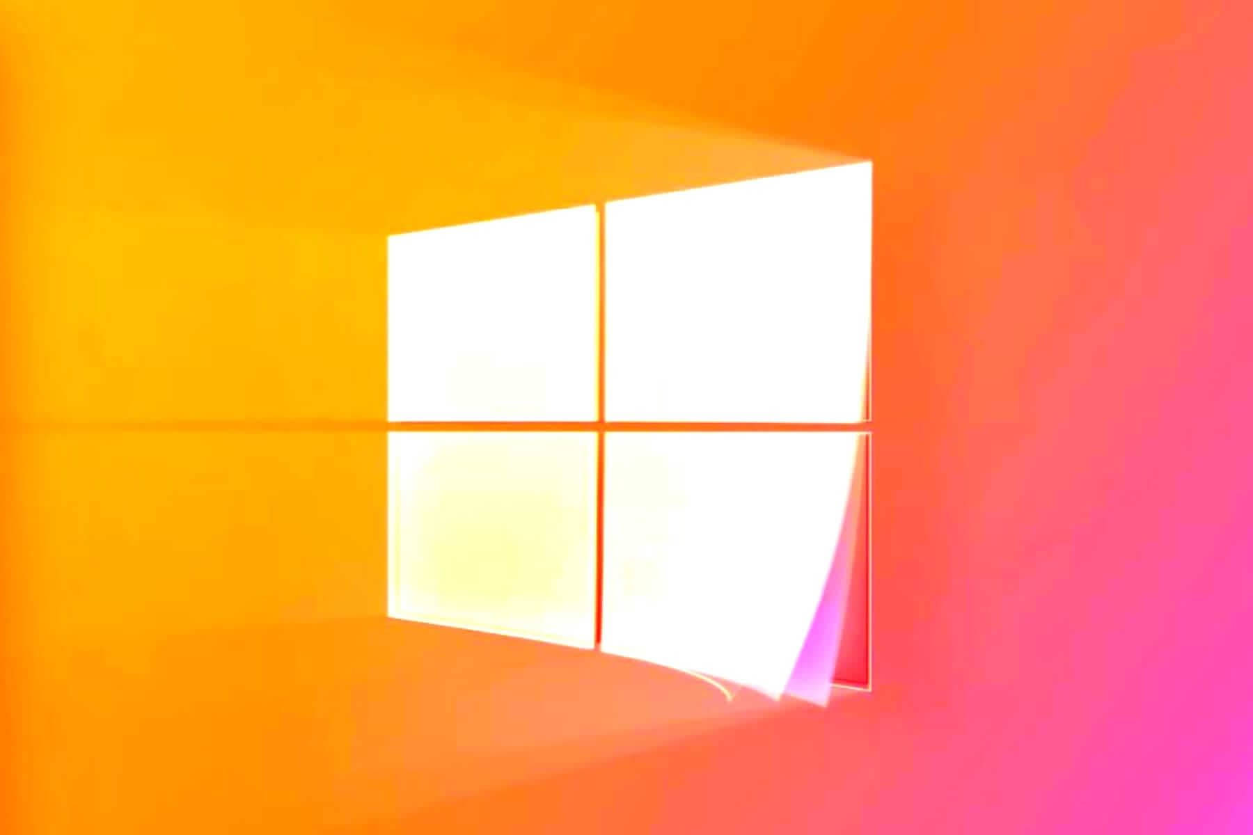 Windows 11 桌布 壁紙 — 一扇發光的四格窗戶，將明亮的光線投射到橙色和粉紅色漸變的牆壁上。