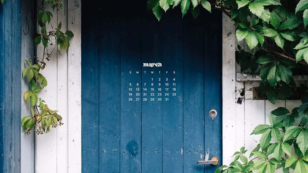 March Desktop 桌布 壁紙 — 一扇飽經風霜的藍色木門，被茂密的綠色藤蔓環繞，展示著清晰白色文字的3月日曆。