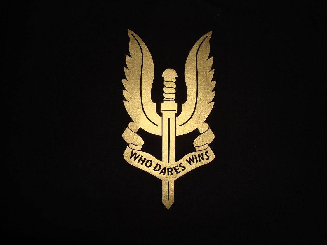 Badge 桌布 壁紙 — 一把帶有翅膀和寫著「who dares wins」橫幅的金色劍在黑色背景上發光。