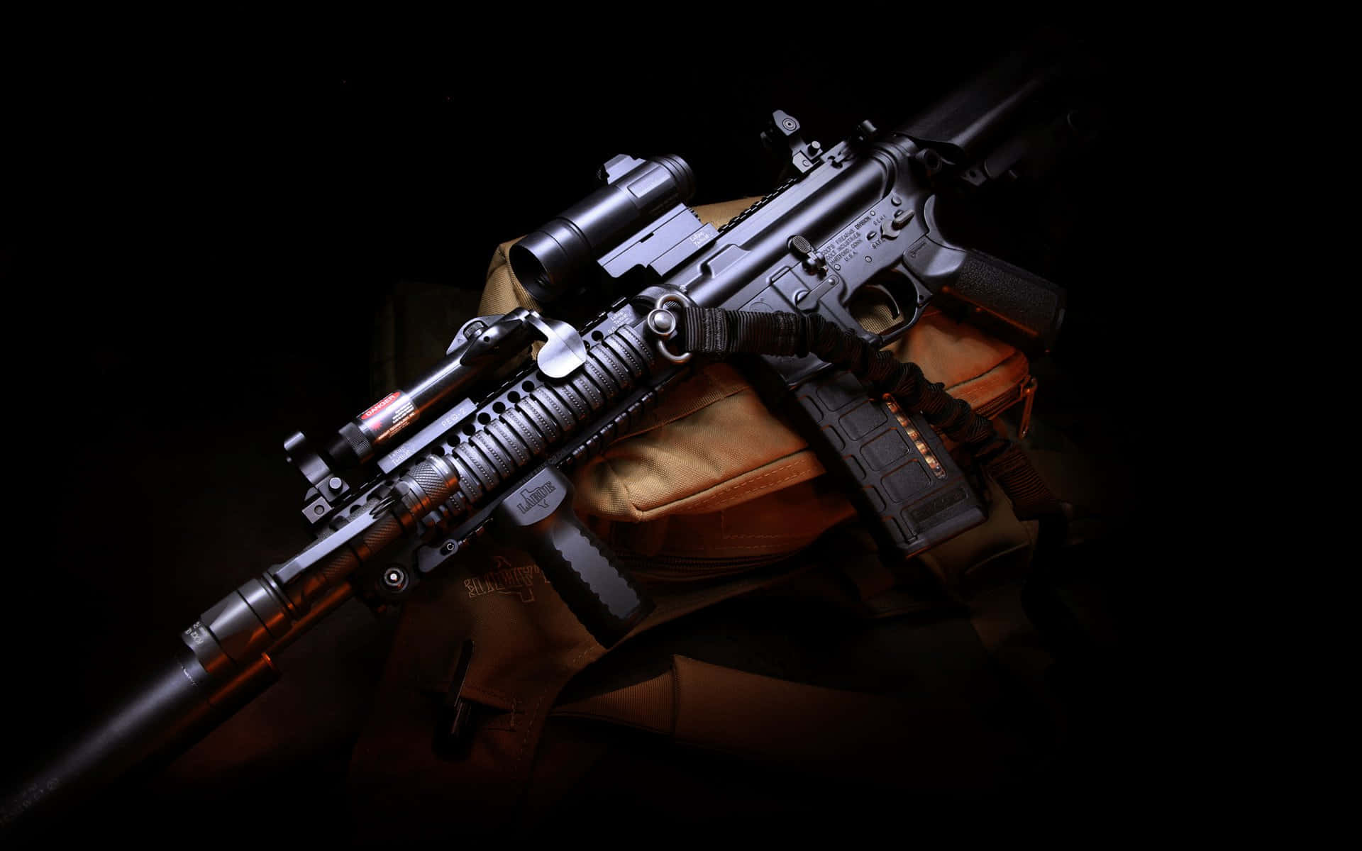 Rifle 桌布 壁紙 — 一把帶瞄準鏡和配件的戰術步槍戲劇性地放在一件棕褐色戰術背心上，背景為黑色。