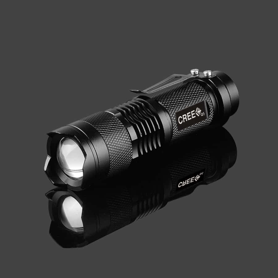 Flashlight 桌布 壁紙 — 一把時尚的黑色CREE手電筒，帶有紋理握把和反光表面，放置在深灰色背景上。
