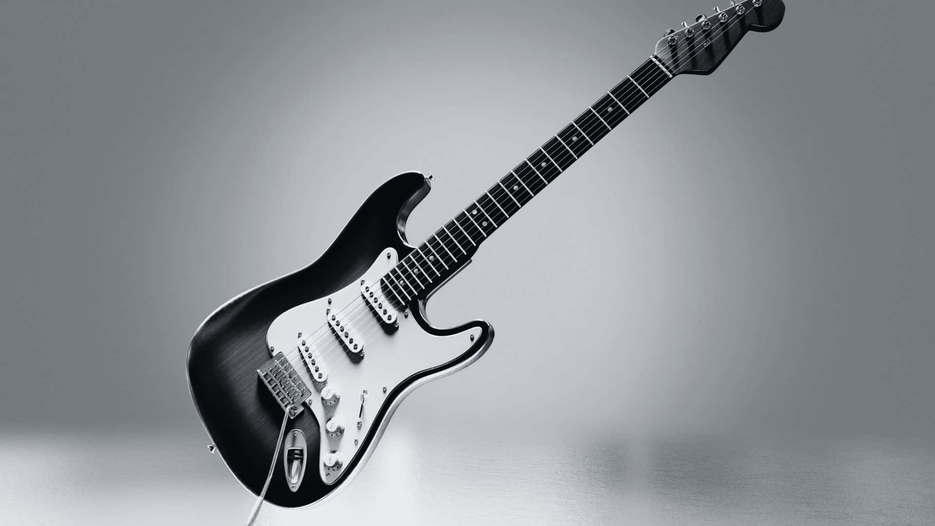 Black And White Guitar 桌布 壁紙 — 一把時尚的黑色電吉他配白色護板，在柔和的灰色漸變背景上對角懸浮。