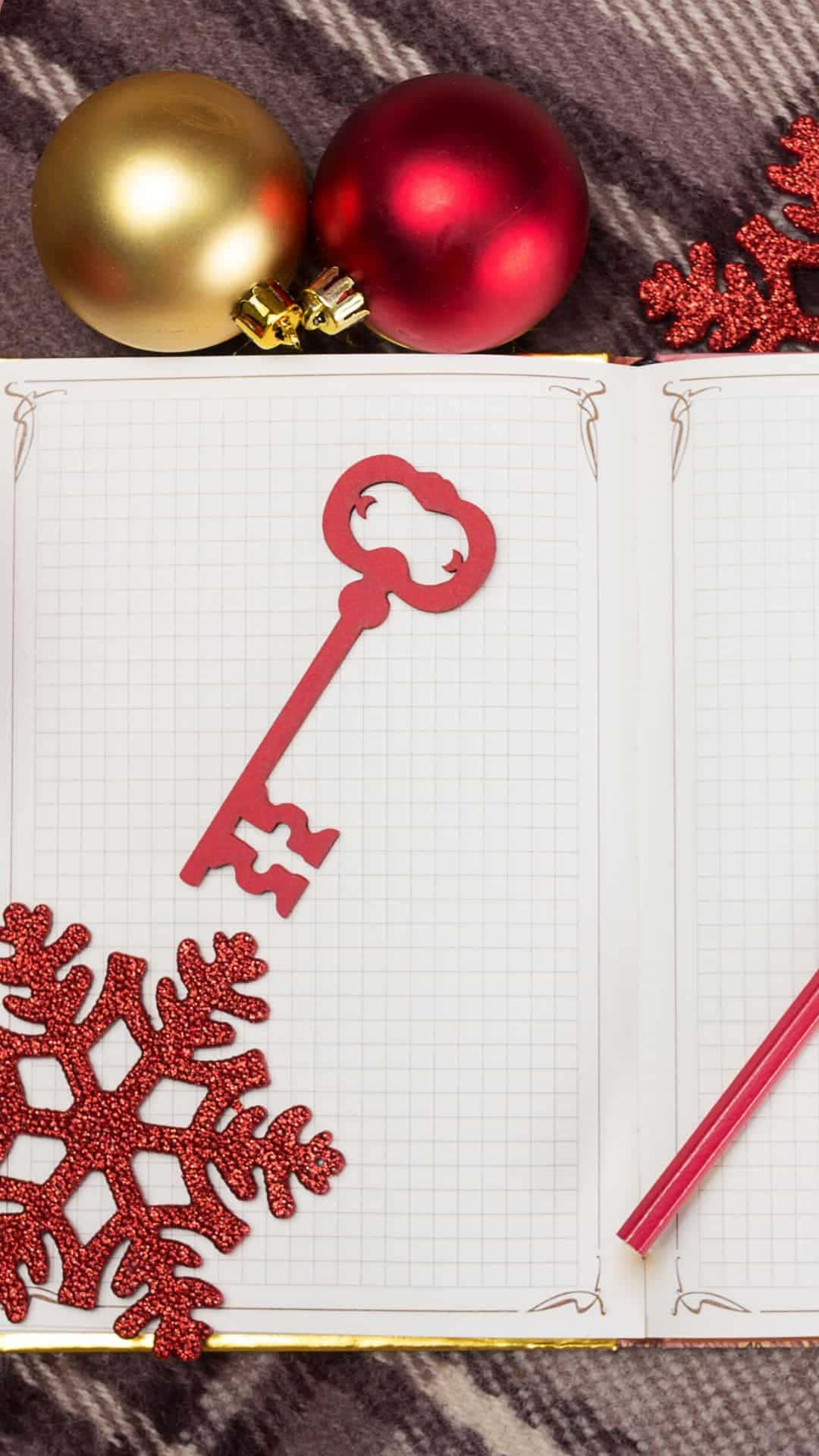 紅色閃亮鑰匙在筆記本上，配有聖誕裝飾和雪花 — 雪花 GIF 壁紙