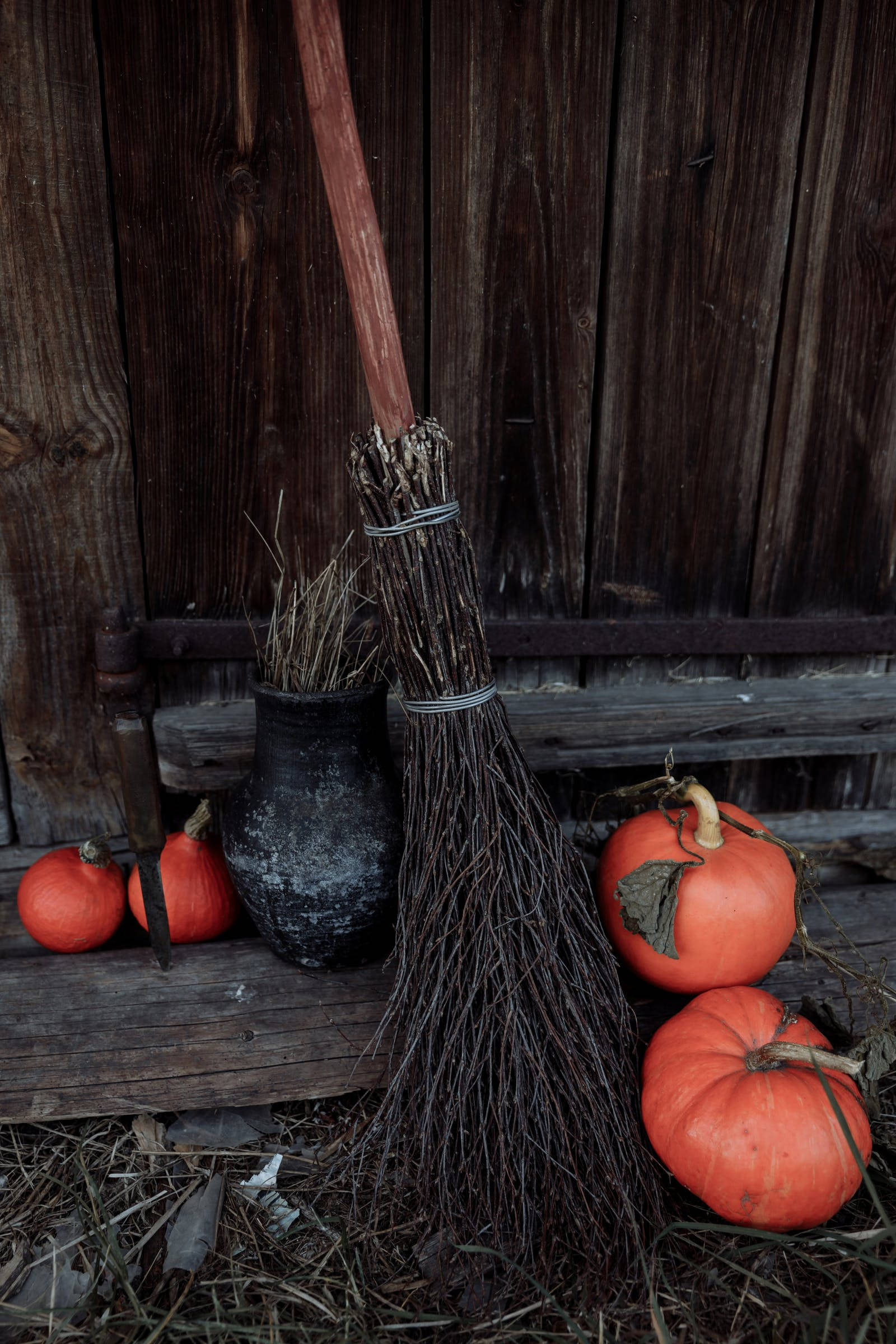Rustic 桌布 壁紙 — 一把鄉村風格的掃帚靠著橙色南瓜和一個黑色壺，倚在風化的木板上。