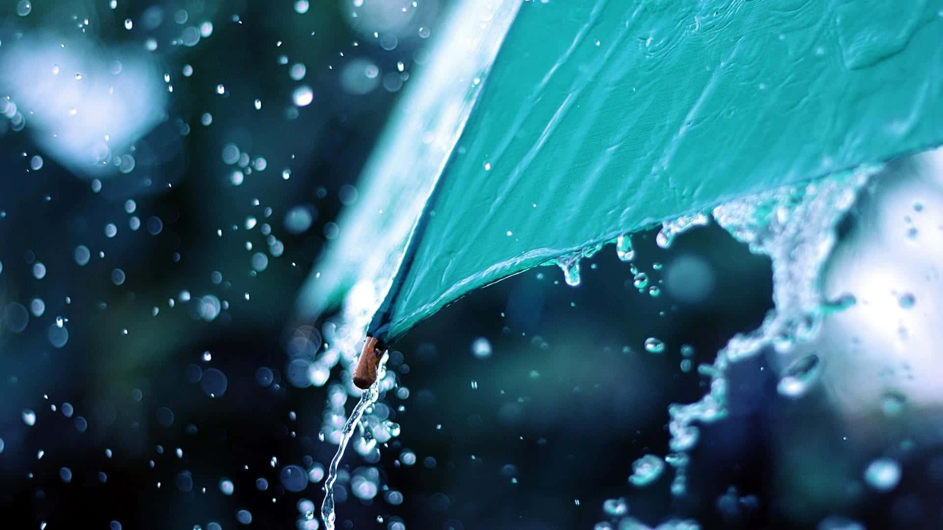 Raining 桌布 壁紙 — 一把青綠色雨傘在雨中場景滴下水珠，閃爍的水滴和模糊的黑暗背景。