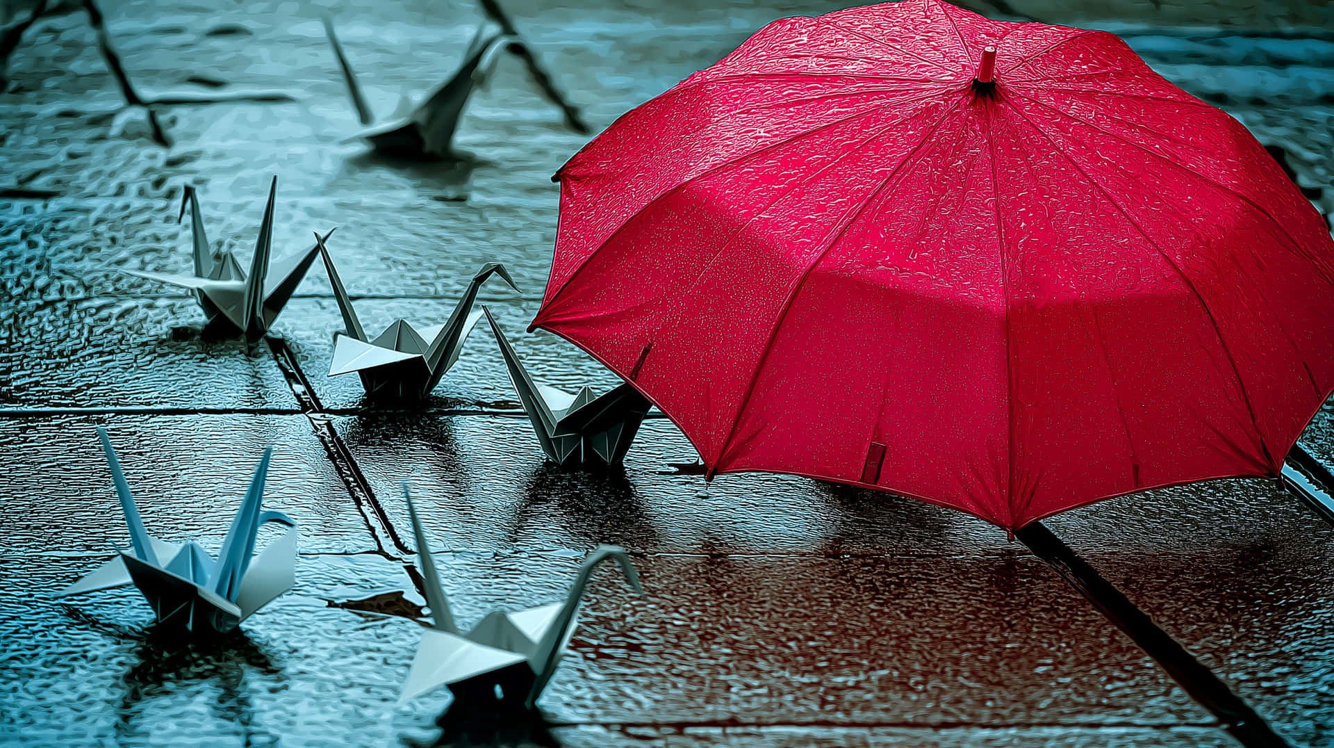 Red Umbrella on Rainy Pavement with Scattered Origami Cranes 壁紙 — 一把鮮紅色的雨傘在雨天保護著濕漉漉的石板路上的紙鶴。