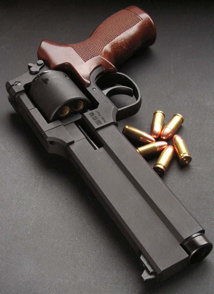 bullet 桌布 壁紙 — 一把黑色左輪手槍搭配棕色握把，斜放在深色紋理表面上，旁邊散落著黃銅子彈。