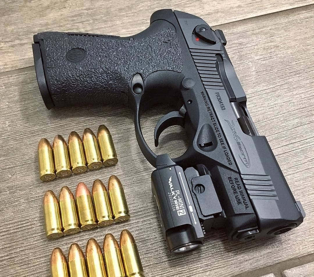 bullet 桌布 壁紙 — 一把黑色訓練手槍，配有雷射瞄準器和金色子彈，排列在木質表面上。