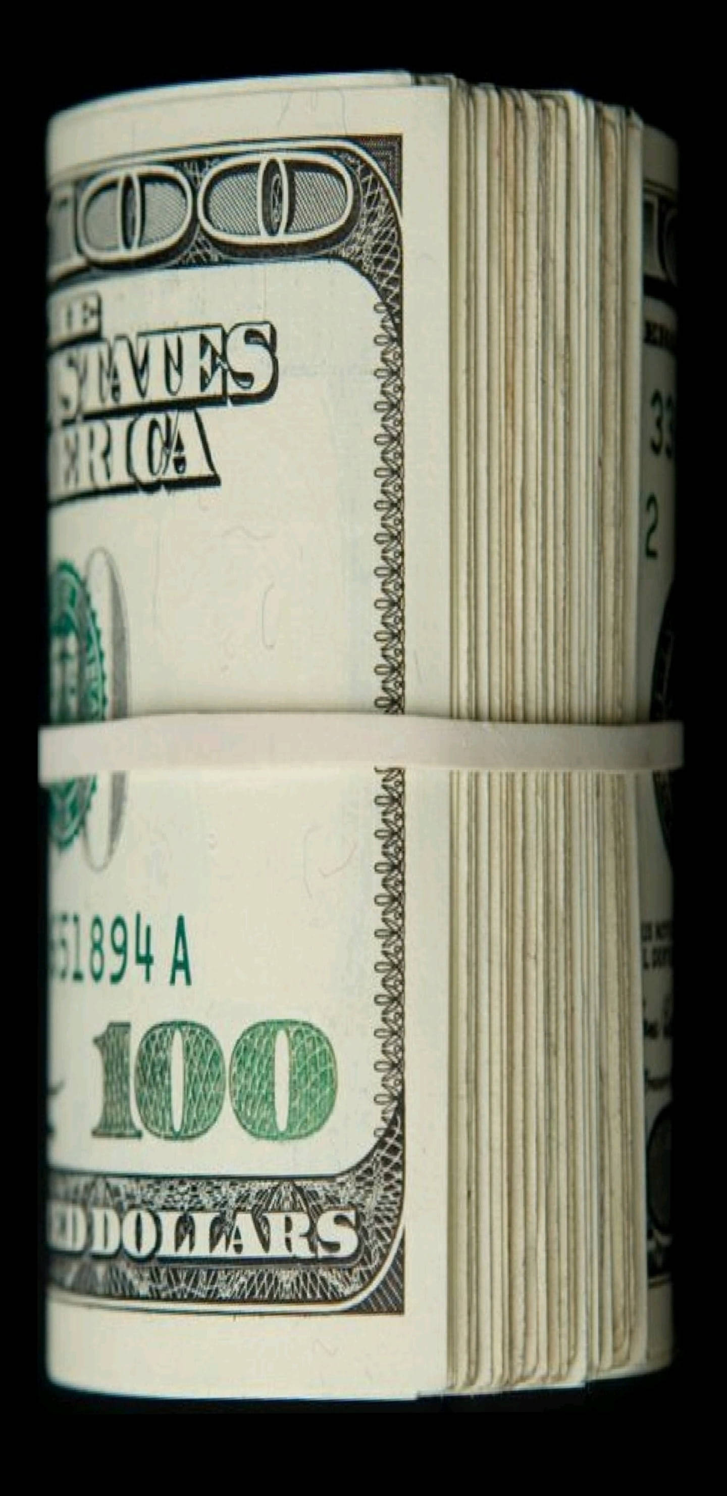money iPhone 桌布 壁紙 — 一捆緊緊捲起的美國一百美元鈔票，用白色帶子固定，背景為黑色。