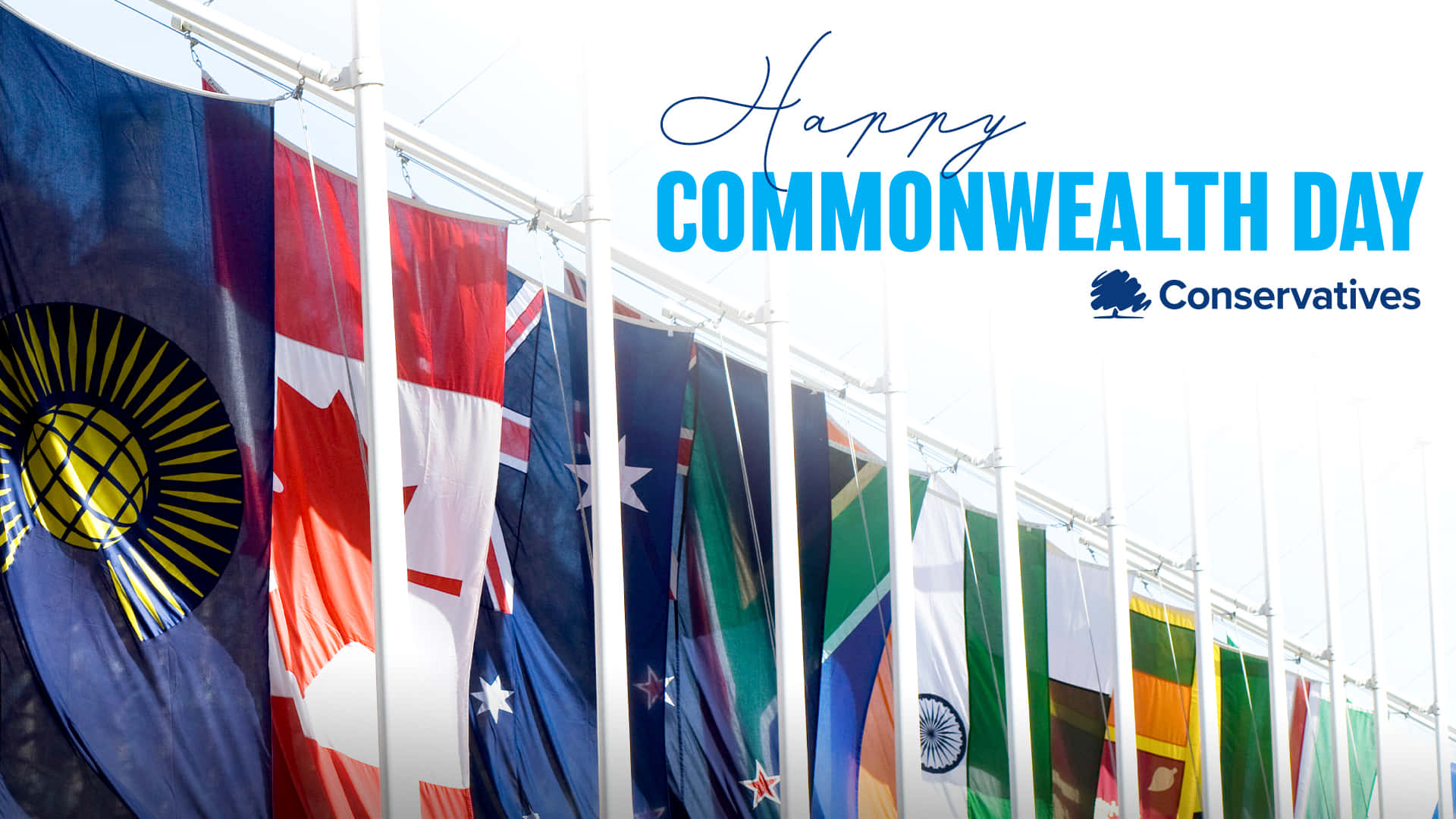 Commonwealth Day 桌布 壁紙 — 一排大英國協國家的旗幟在明亮的日光下飄揚，上方掛著「大英國協日快樂」橫幅。