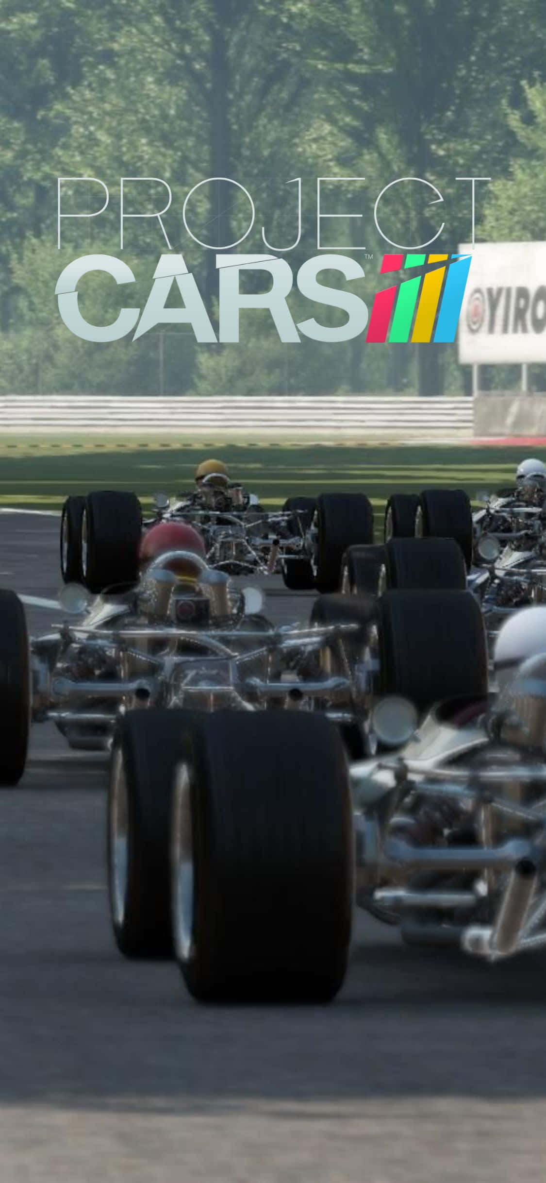 iPhone Xs Project Cars 桌布 壁紙 — 一排復古開輪賽車排列在陽光明媚的賽道上，背景有綠樹。