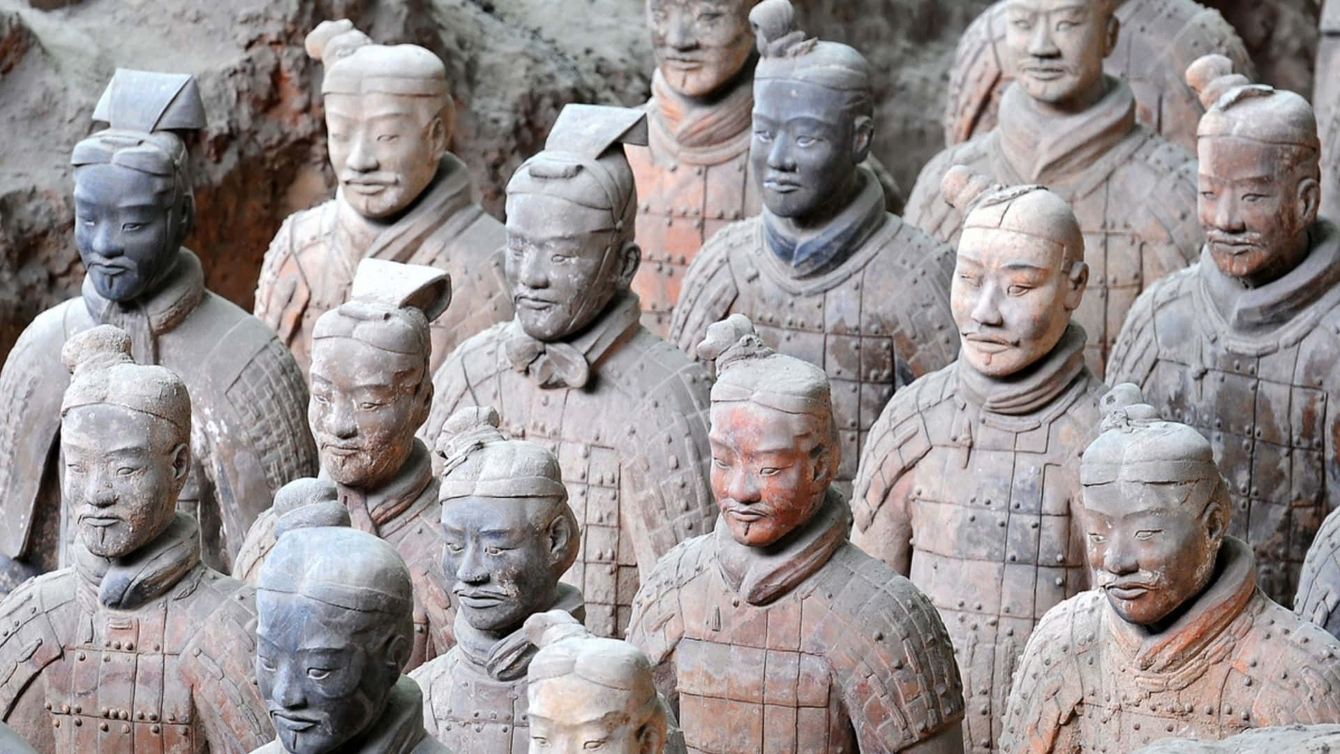 Museum 桌布 壁紙 — 一排排古代兵馬俑莊嚴地矗立在發掘坑中，帶有泥土色調和風化的盔甲。