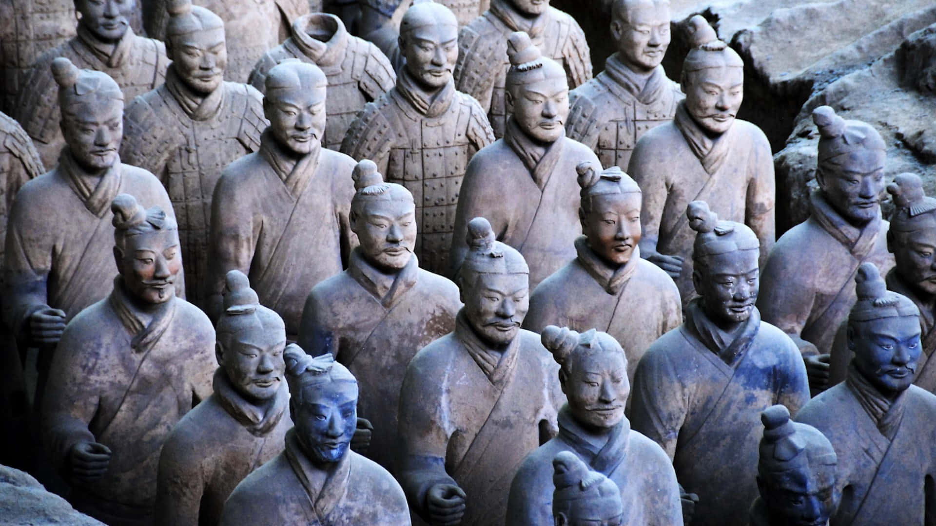 Museum 桌布 壁紙 — 一排排古老的兵馬俑莊嚴地矗立在地下坑道中，呈現泥土色調和精細的盔甲。