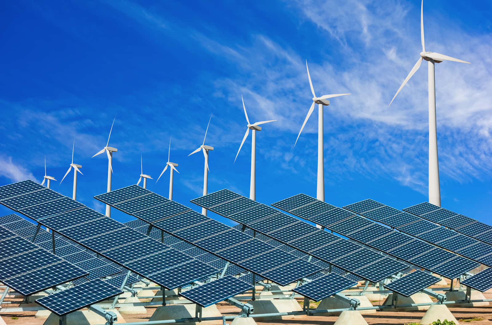 電力 桌布 壁紙 — 一排排太陽能板和風力發電機矗立在晴朗藍天和薄雲之下。