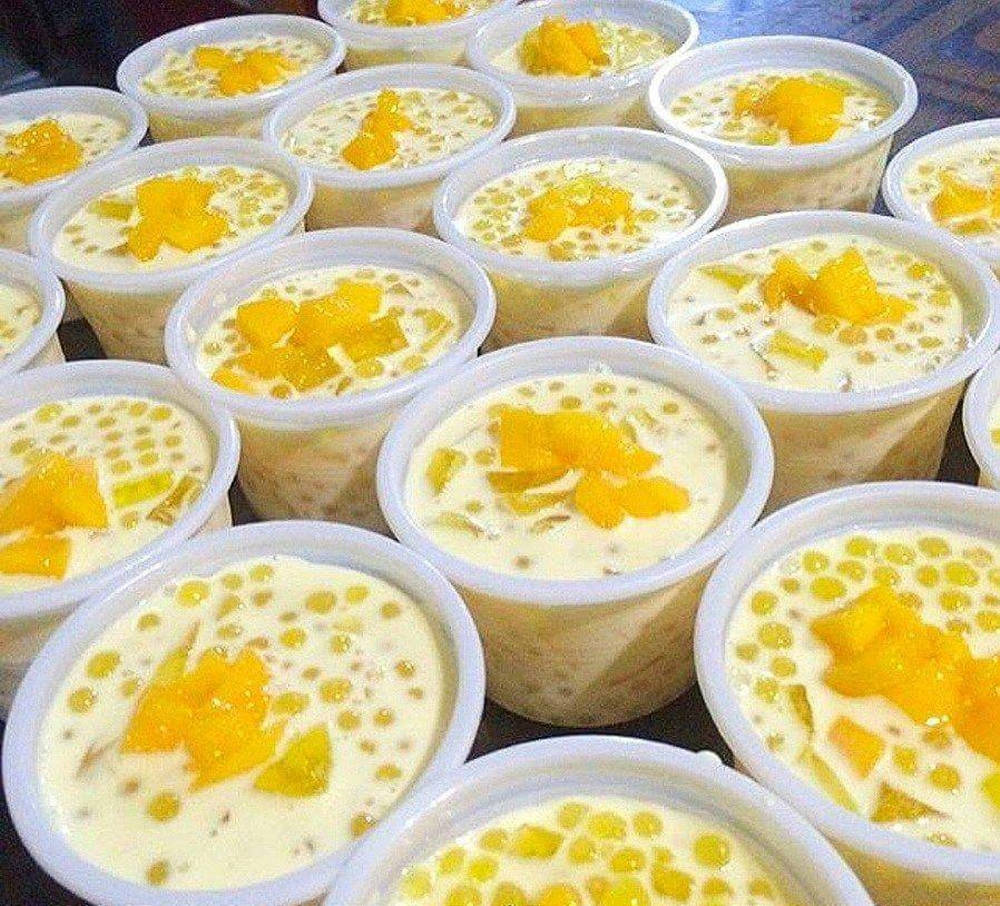 Mango 桌布 壁紙 — 一排排奶油椰子奶甜點，上面放有多汁芒果塊和木薯珍珠，裝在白色杯子裡。