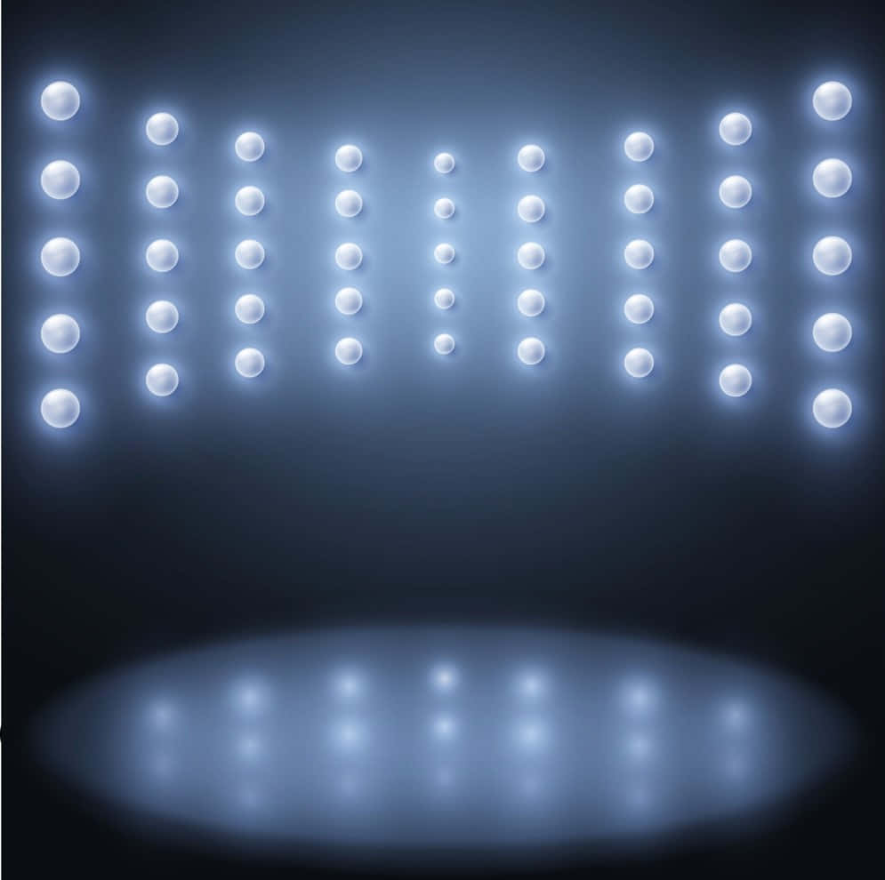 Stage Light 桌布 壁紙 — 一排排明亮的白色舞台燈照亮了昏暗的劇院，下方地板上有一個發光的聚光燈。