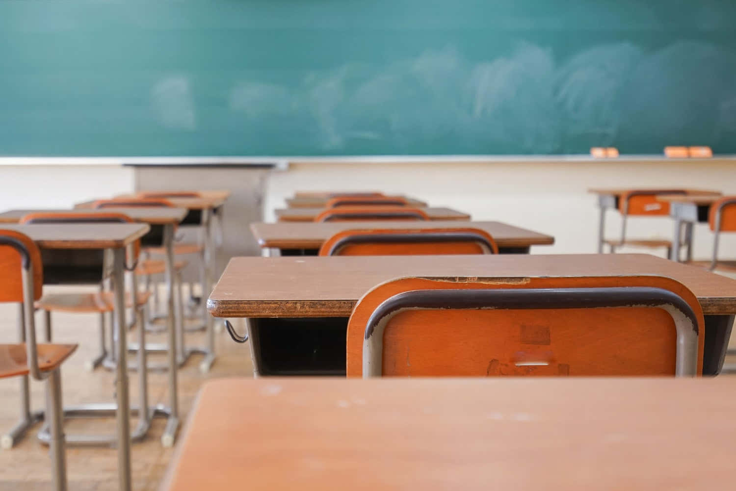School Photo 桌布 壁紙 — 一排排木製書桌和椅子面向空蕩蕩的學校教室裡佈滿灰塵的綠色黑板。