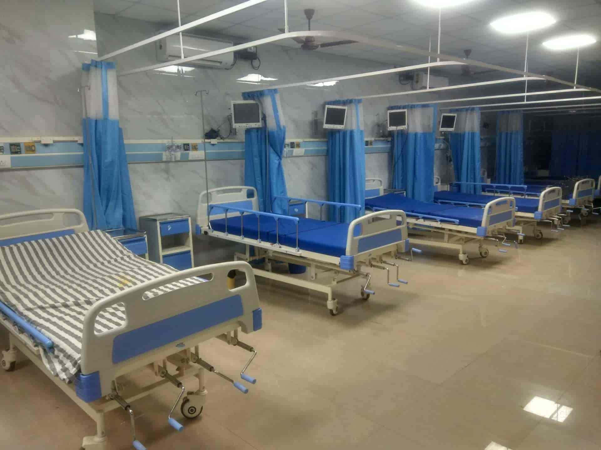 Hospital 桌布 壁紙 — 一排排空置的醫院病床，配有藍色簾幕和監視器，在明亮的螢光燈下處於無菌病房。