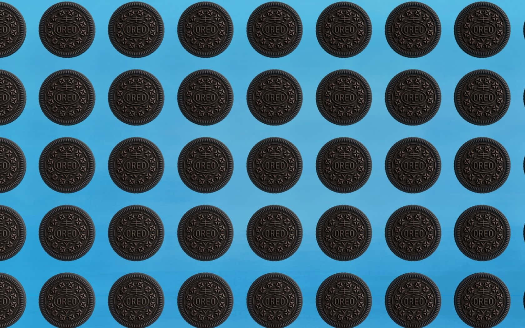 Oreo Cookie 桌布 壁紙 — 一排排經典的Oreo餅乾整齊排列在純藍色背景上。