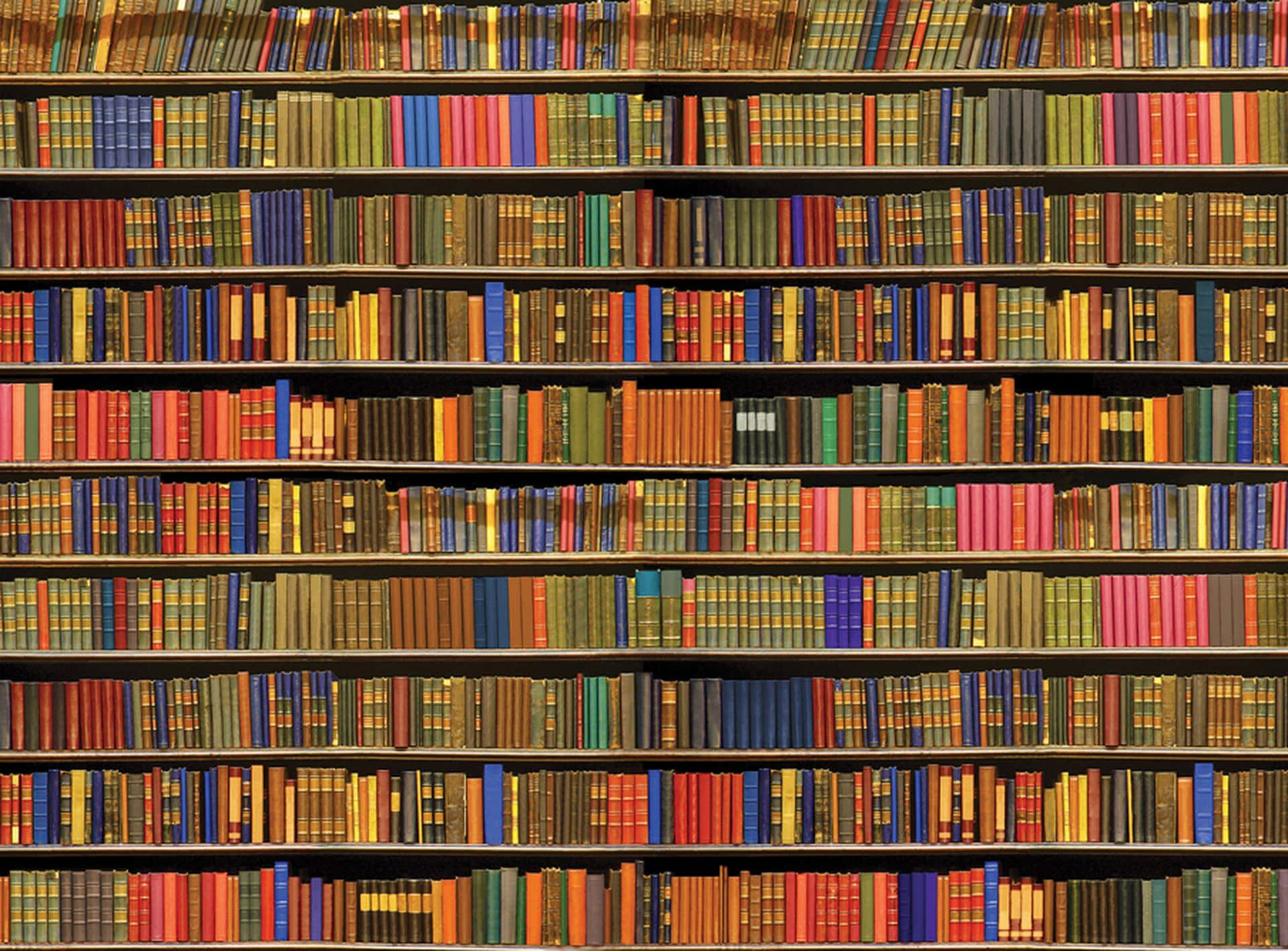 書本 桌布 壁紙 — 一排排色彩繽紛書脊的復古書籍填滿了舒適圖書館的木製書架。