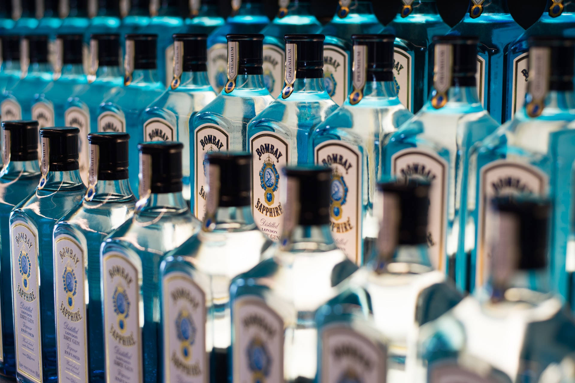 Wine 桌布 壁紙 — 一排排藍色 Bombay Sapphire 琴酒瓶在明亮光線下閃爍，景深較淺。