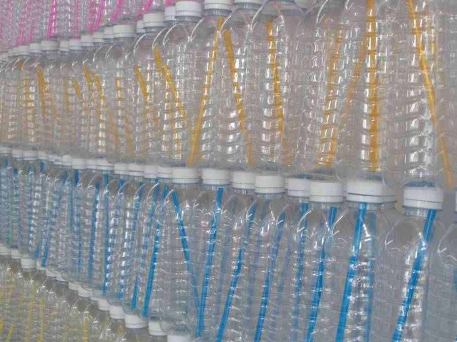 Transparent 桌布 壁紙 — 一排排透明塑膠水瓶配上彩色吸管整齊地堆疊在工廠環境中。