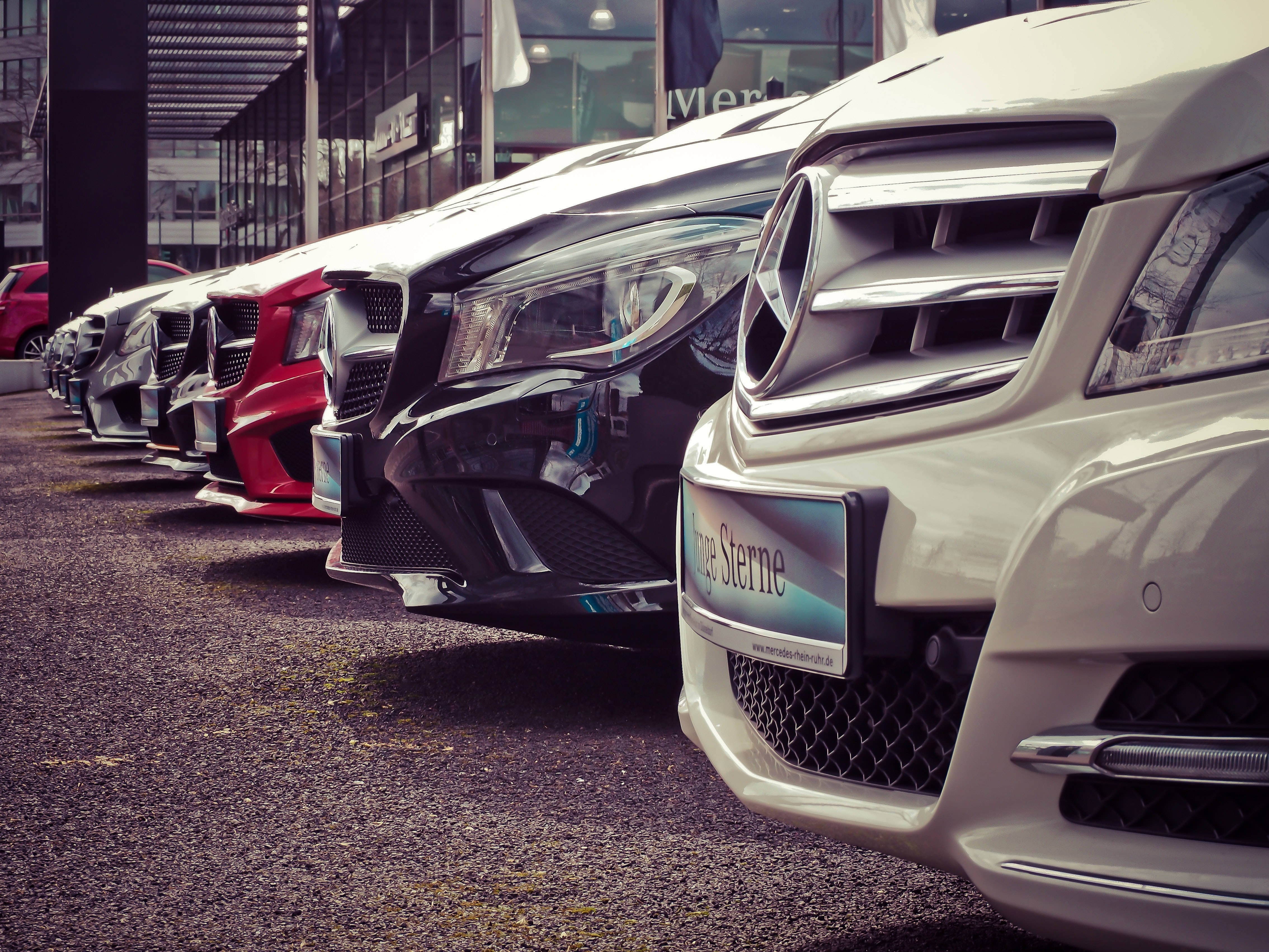 cars 桌布 壁紙 — 一排時尚豪華汽車，帶有鍍鉻裝飾和光澤飾面，停放在現代化的經銷商場地。