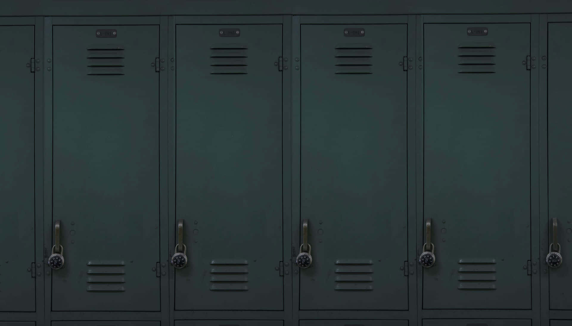 Locker 桌布 壁紙 — 一排深綠色金屬置物櫃，每個門上都掛著掛鎖，位於燈光昏暗的走廊中。