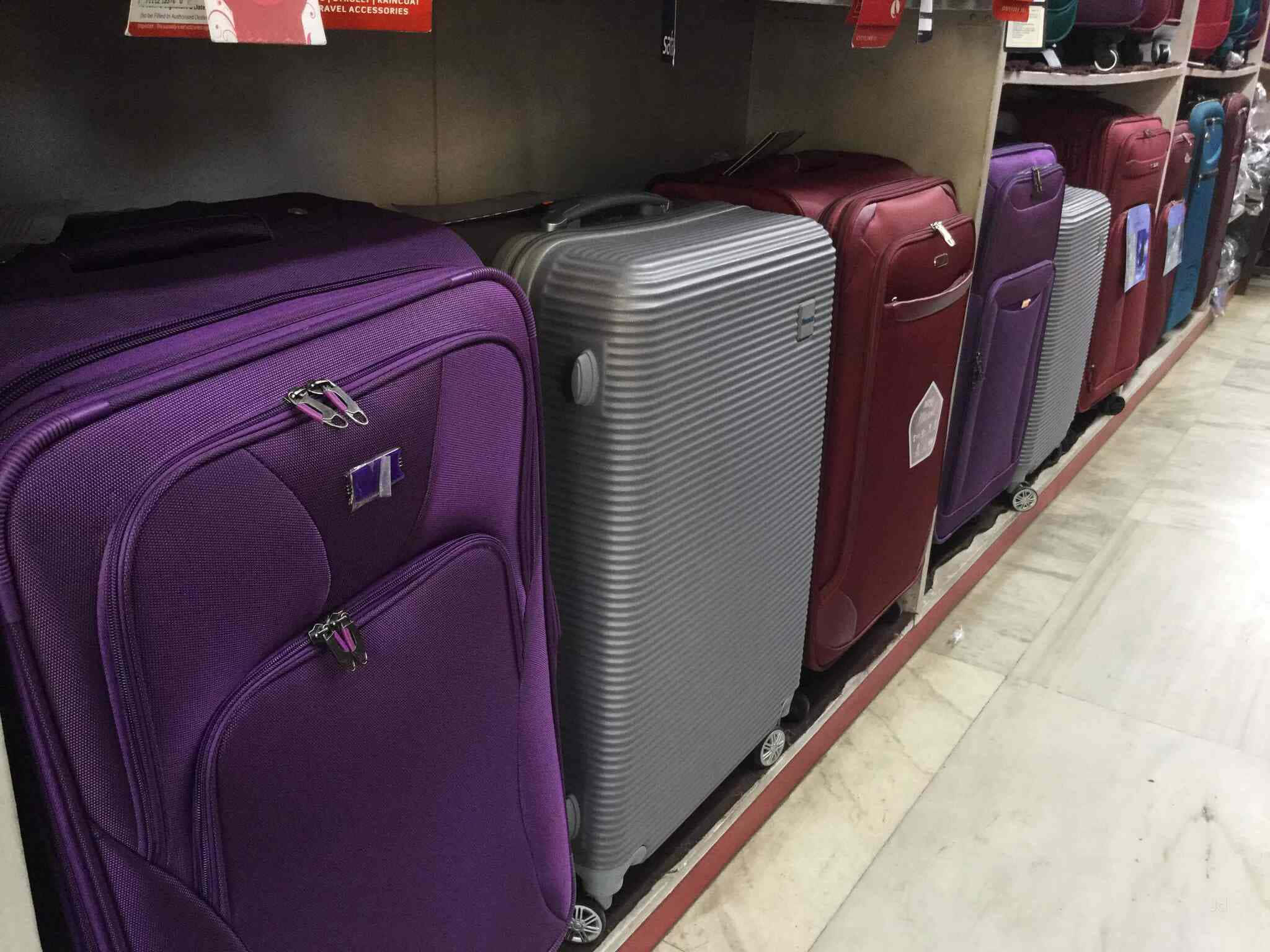 Purple Luggage 桌布 壁紙 — 一排紫色、灰色和紅色的彩色硬殼行李箱整齊排列在商店貨架上，價格標籤清晰可見。