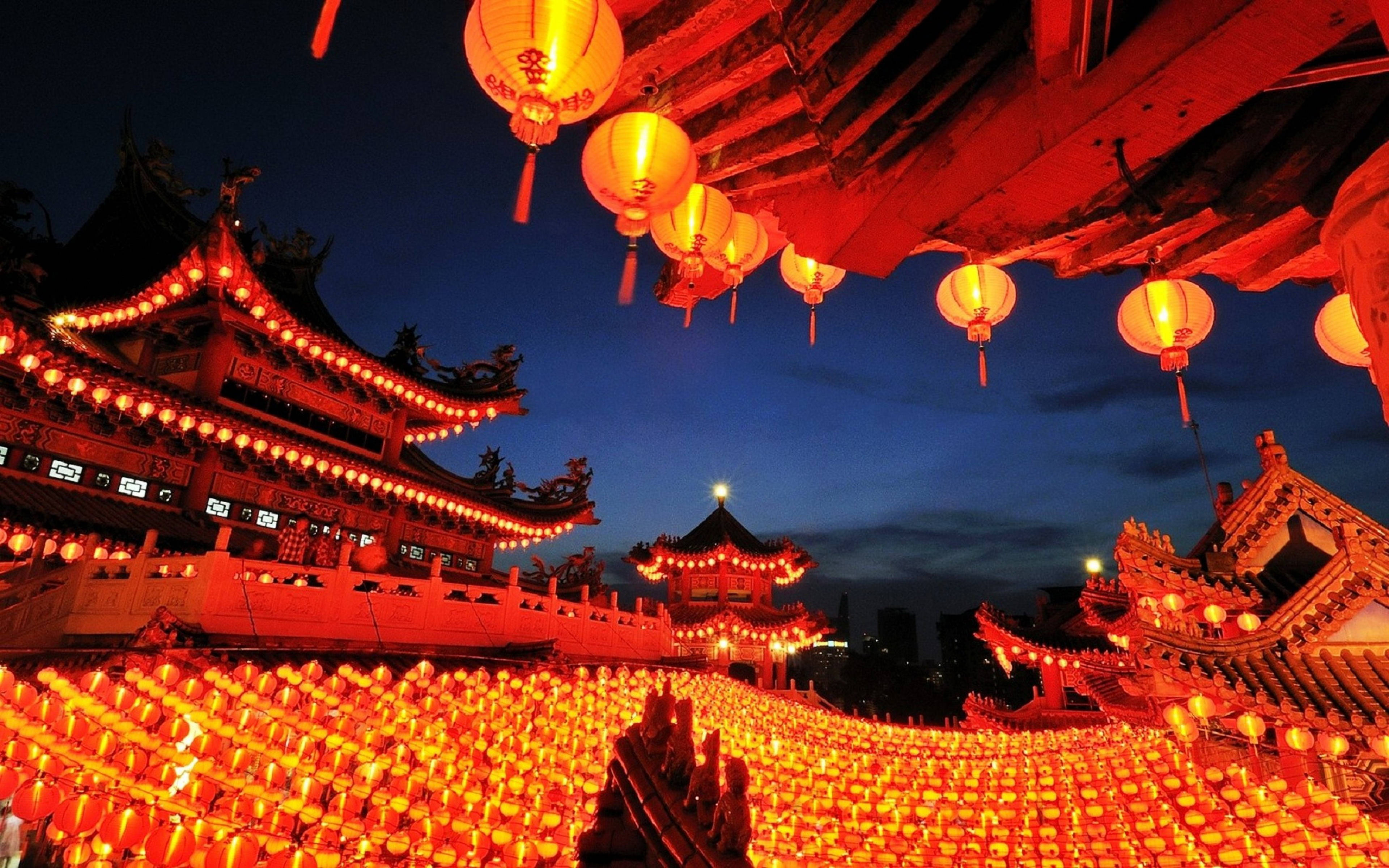 Malaysia 桌布 壁紙 — 一排耀眼的紅色發光燈籠照亮了傳統中式建築，背景是深沉的暮色天空。