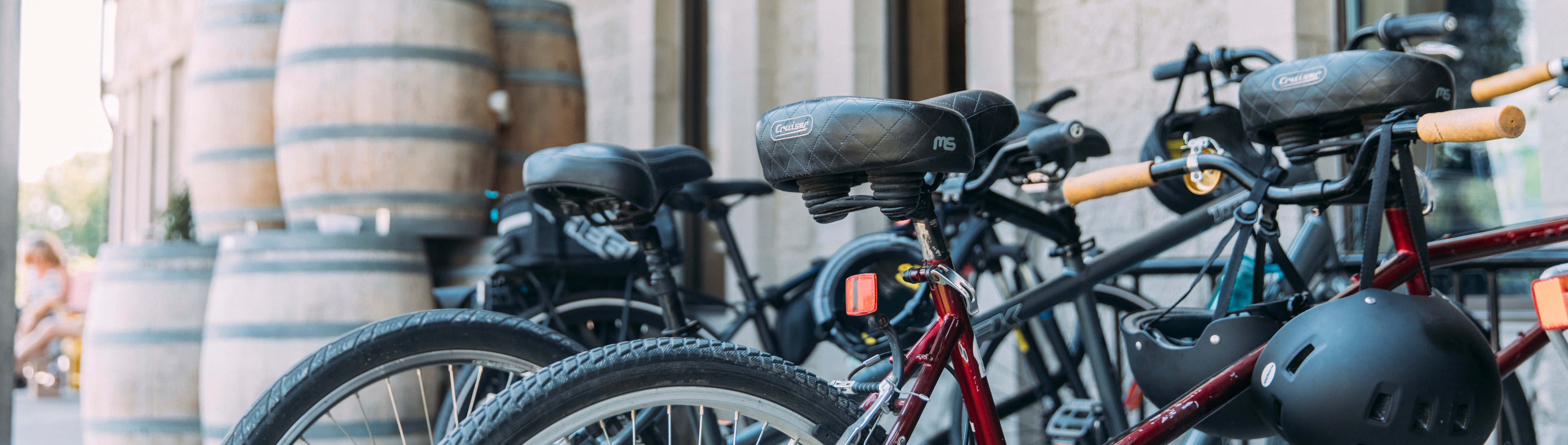 Best Bikes 桌布 壁紙 — 一排腳踏車停放在陽光普照的城市庭院中的大型木製酒桶旁。