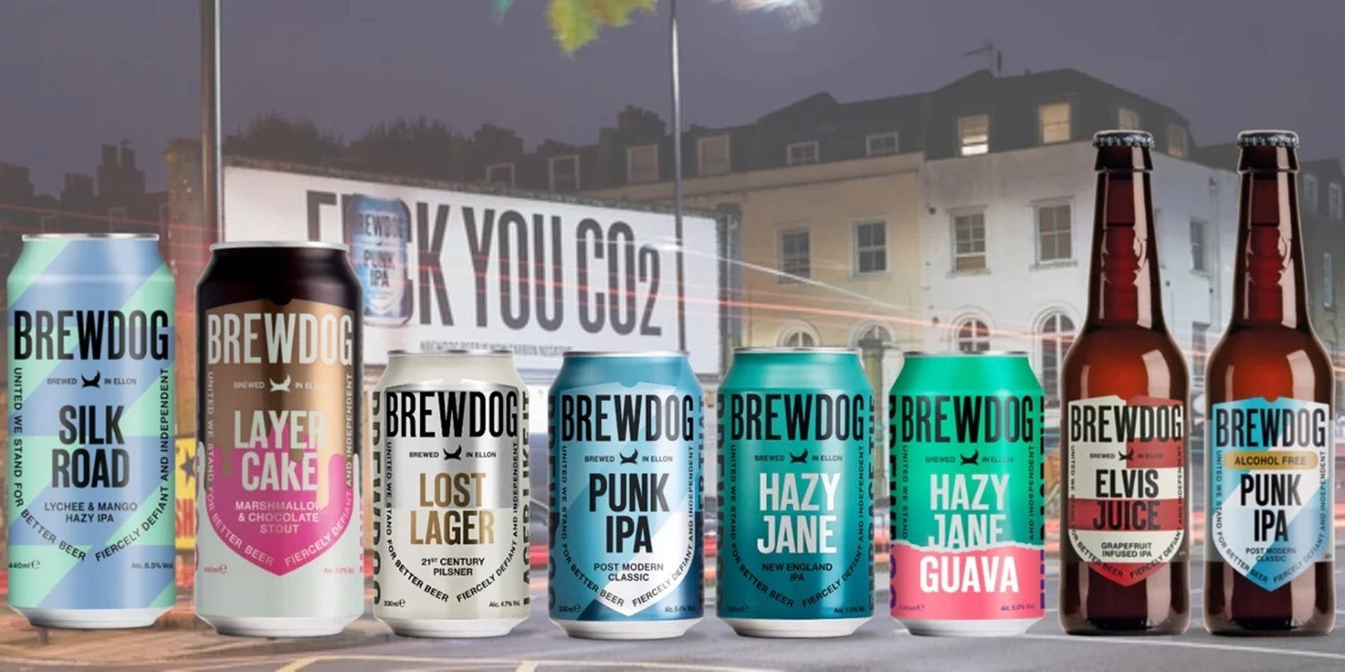 Drink 桌布 壁紙 — 一排色彩繽紛的BrewDog啤酒罐和啤酒瓶展示在一棟帶有「F**K YOU CO2」標誌的建築物前。