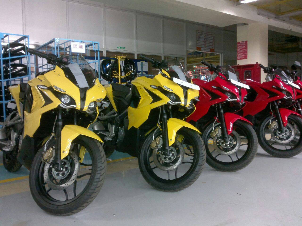 Racing 桌布 壁紙 — 一排鮮黃色和紅色的運動機車停放在倉庫內，背景有藍色貨架。