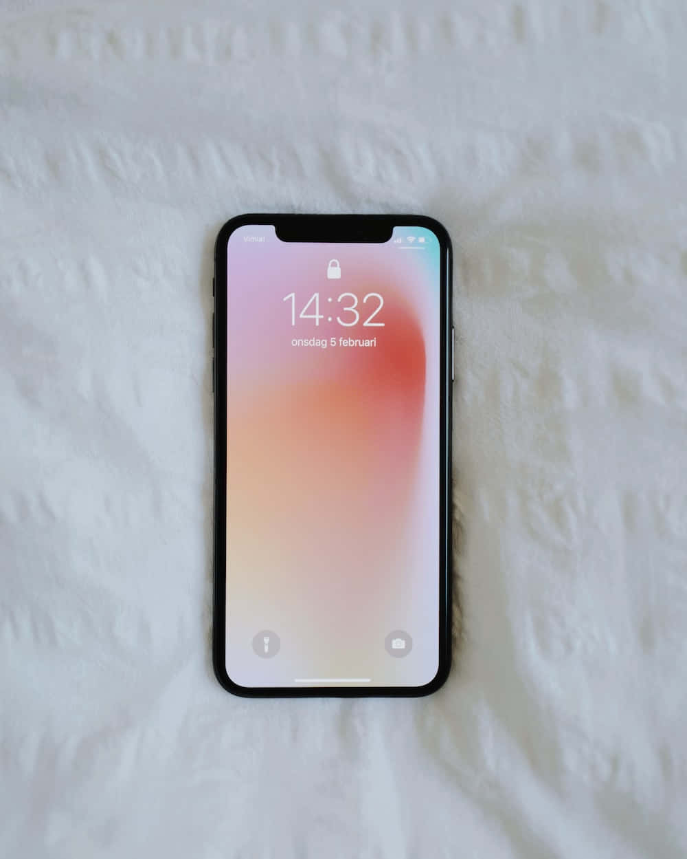 一支iPhone X 正躺在床上 壁紙