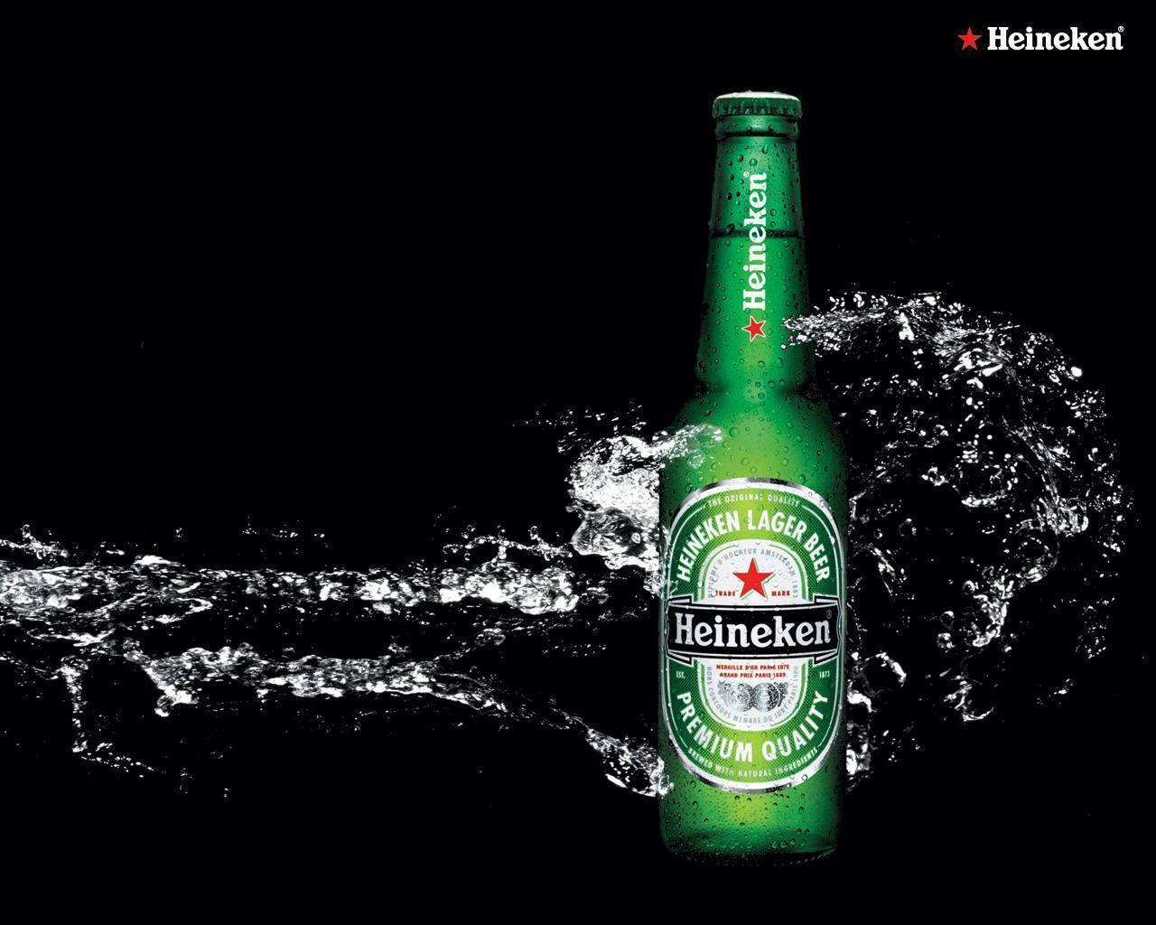 Drink 桌布 壁紙 — 一支冰涼的綠色海尼根啤酒瓶在純黑色背景中穿過水花飛濺。