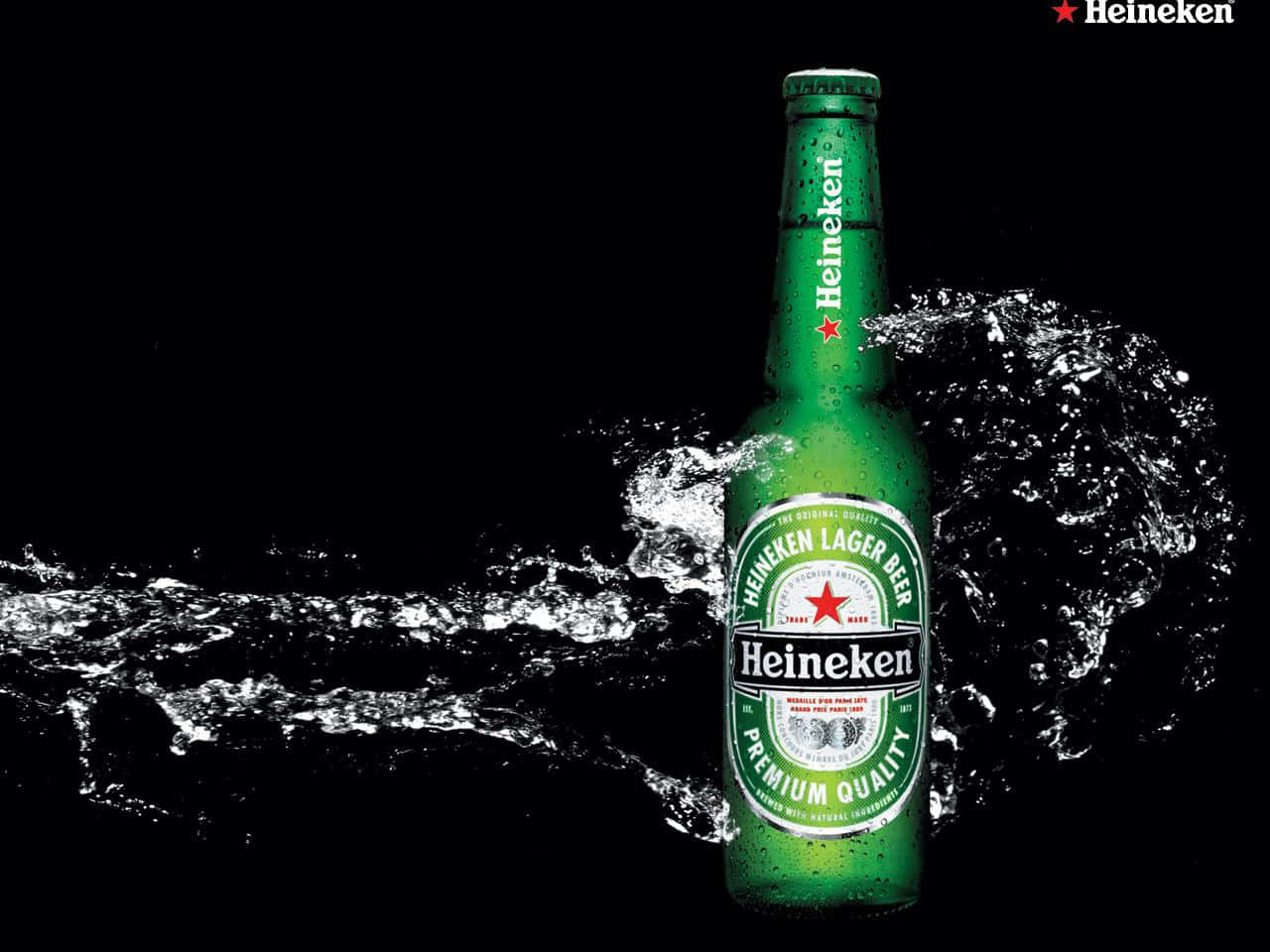 Heineken 桌布 壁紙 — 一支冰涼的綠色海尼根啤酒瓶在純黑色背景下濺起水花。