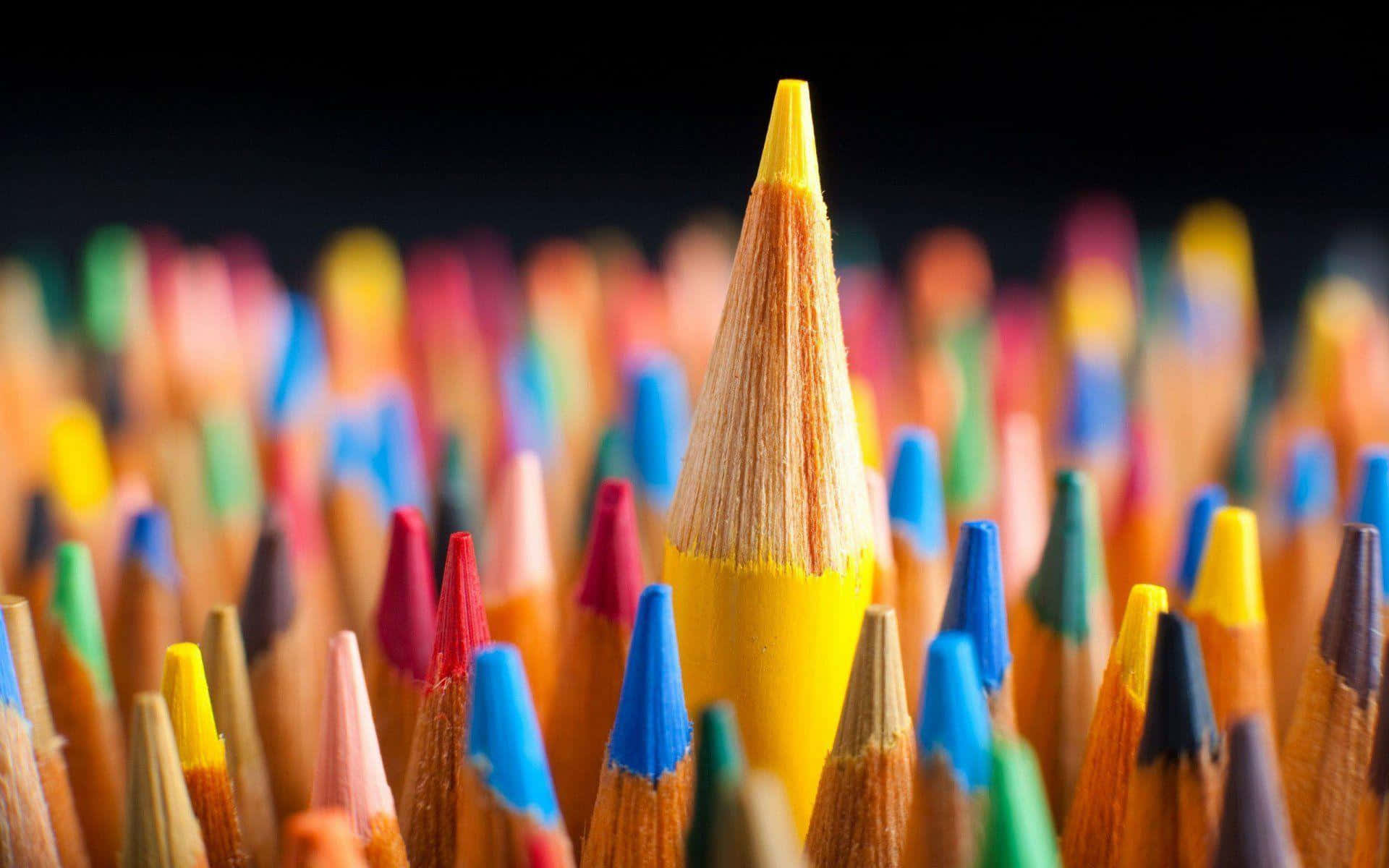 crayon 桌布 壁紙 — 一支尖銳的黃色鉛筆在淺景深中，聳立在色彩繽紛的鉛筆海洋中。