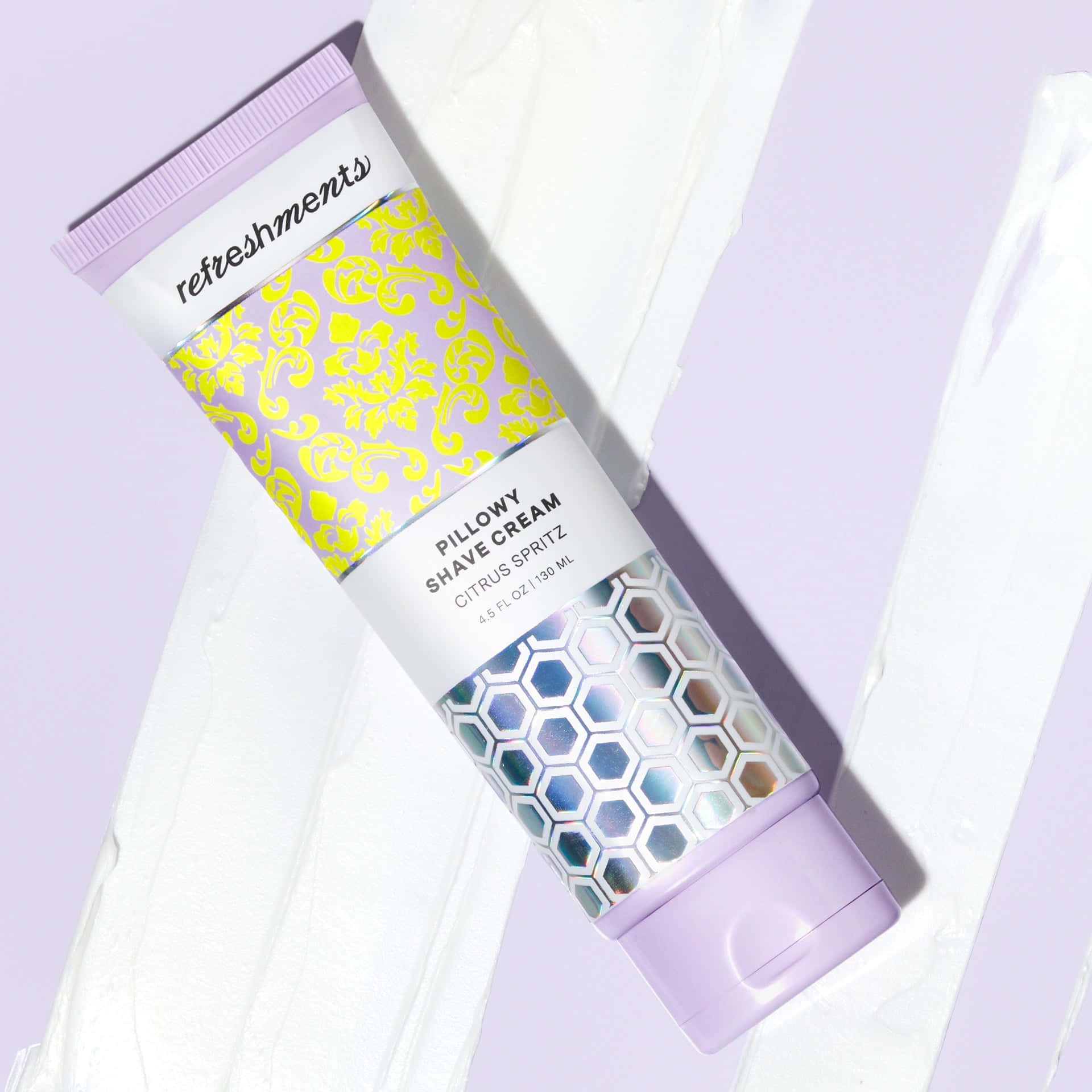 Shaving Cream 桌布 壁紙 — 一支帶有柑橘噴霧的Refreshments Pillowy Shave Cream刮鬍膏管斜放在薰衣草背景上，帶有白色奶油漩渦。
