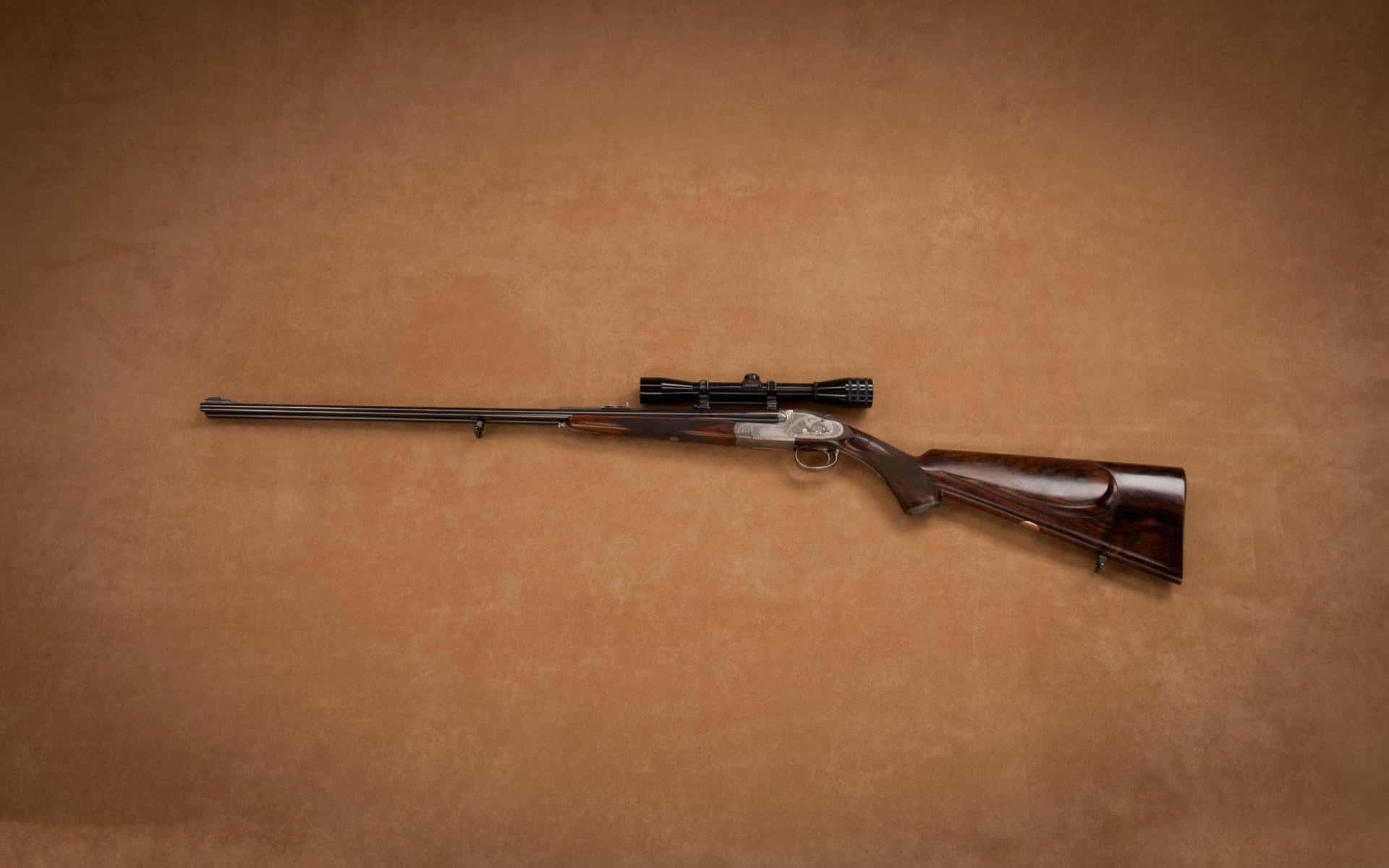 Rifle 桌布 壁紙 — 一支時尚的栓動步槍，配有木質槍托和瞄準鏡，放置在帶紋理的棕色背景上。