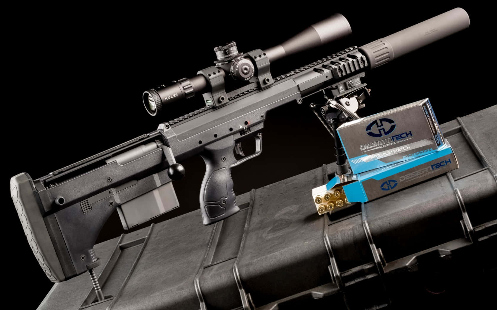 Rifle 桌布 壁紙 — 一支時尚的黑色戰術步槍，配有瞄準鏡和消音器，放在一個堅固的箱子上，旁邊是沙漠科技彈藥盒，背景為純黑色。