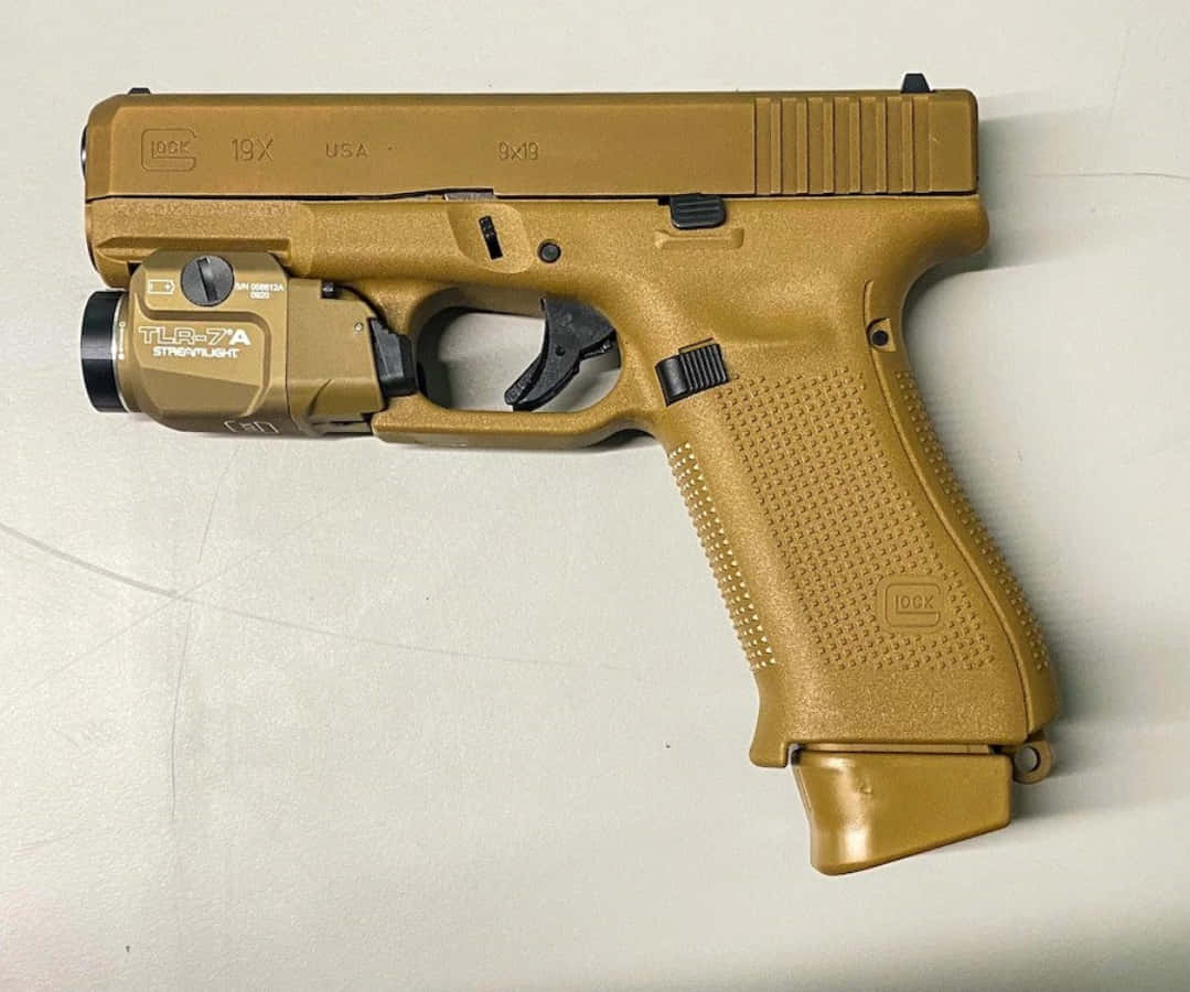 Glock 19 桌布 壁紙 — 一支沙色Glock 19X手槍，配有TLR-7A戰術手電筒，放置在純白色表面上。